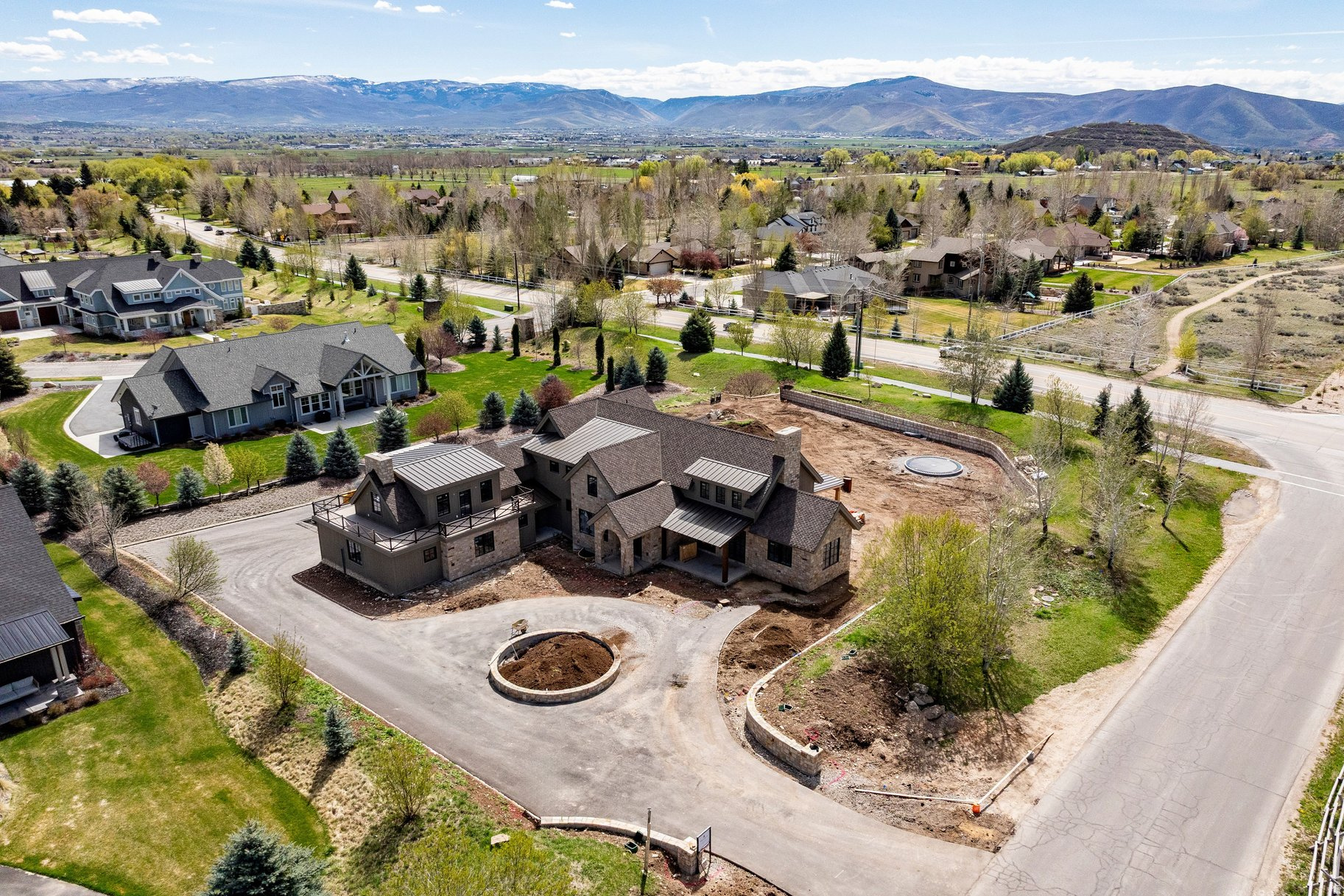 Welcome to this exceptional new construction home at 1070 N. Interlaken Drive, nestled in the highly sought-after Deer Ridge Estates neighborhood of Midway. Built by the esteemed Branca Homes, this expansive 6,691 square foot residence sits on a private 1-acre parcel, offering a peaceful retreat with breathtaking mountain views.  On the main level, you'll find the luxurious primary bedroom suite, featuring a spacious, spa-like en suite bathroom with premium finishes and ample space for relaxation. The open-concept floor plan is designed for both comfort and style, with an inviting kitchen at the heart of the home. The large center island is perfect for entertaining, while the adjoining living and dining areas offer plenty of space for gatherings. The main level also includes a convenient laundry room and a versatile office/den  ideal for working from home or as a quiet space to unwind.  Upstairs, the home is perfectly suited for families with three generously-sized, en-suite bedrooms, each offering privacy and comfort. A cozy family room area provides a perfect space for relaxation or play.  The lower level is an entertainer's dream, with a second family room and wet bar, creating an ideal space for movie nights, game days, or casual get-togethers. Two additional bedrooms provide ample space for guests or extended family, and there's plenty of room for storage, ensuring the home is as practical as it is beautiful.  Deer Ridge Estates is truly a gem in Midway, offering an exceptional blend of privacy and convenience. Located within 15 minutes from the new Deer Valley East Village Resort, you'll have easy access to world-class skiing, mountain biking, and outdoor recreation year-round.  This home is an outstanding opportunity to live in one of the most desirable areas in the region. With stunning design, luxurious finishes, and an incredible location, 1070 N. Interlaken Drive is ready to welcome you home. Don't miss your chance to experience this incredible property firsthand. Anticipated completion of Spring 2026.
