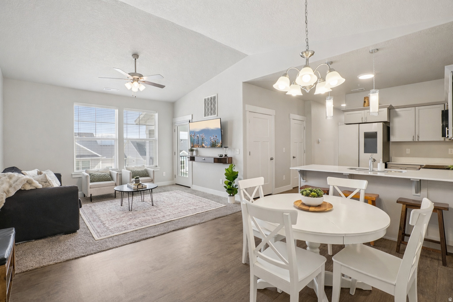 !!! PRICE REDUCED !!! Top-floor showstopper in Wildflower Village 2 with vaulted ceilings and no upstairs neighbors, offering privacy and an open, airy feel that's hard to find. This clean, well-maintained condo features quartz countertops, stainless steel appliances, and stylish designer pendant lighting that elevates the space. Step out onto the covered deck and take in incredible views-perfect for relaxing or entertaining. The spacious primary suite includes a private ensuite bath and a walk-in closet.  Enjoy access to Wildflower Lake and its reservoir, plus community amenities including volleyball, bocce ball, pickleball courts, picnic areas, playgrounds, and scenic biking and walking trails. The Wildflower dog park and dog wash are nearly complete, adding even more to this vibrant, growing community. Residents also have access to a clubhouse and swimming pool, making this an ideal blend of comfort, convenience, and lifestyle.