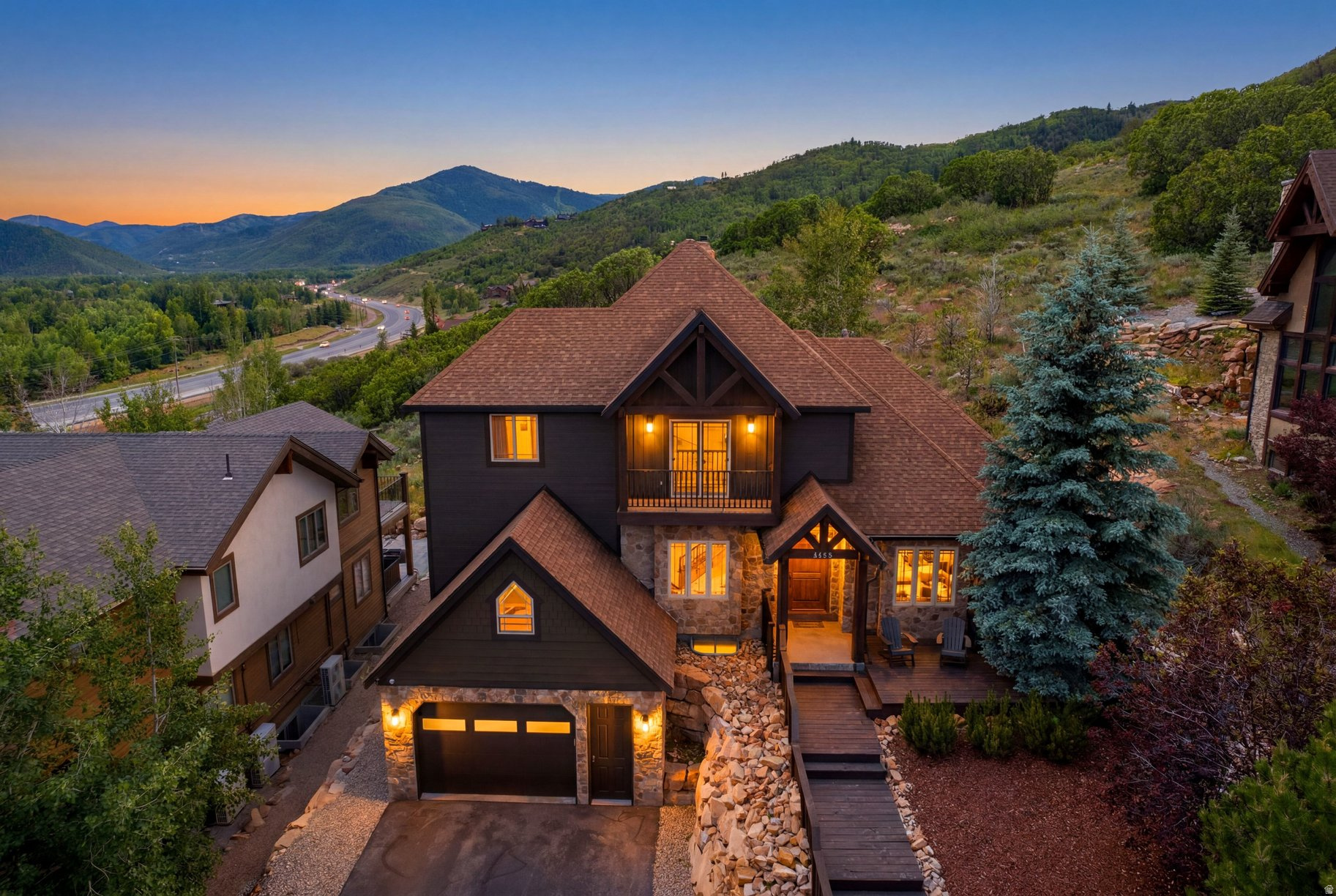 There's a certain ease to life here-the kind that begins the moment you walk through the door and see light pour across wide open spaces, vaulted ceilings, and warm hardwood floors. The home unfolds effortlessly, designed for both gathering and quiet retreat, with a seamless flow from the great room to a gourmet kitchen that invites everything from slow mornings to lively evenings. Step outside onto the expansive deck, which features a saltwater hot tub, backyard turf and a Trex deck. The setting truly reveals itself: sweeping views of surrounding ski resorts and the protected beauty of the Swaner Nature Preserve.  With 5 bedrooms and 4 baths, the home offers space without compromise. the lower level adds flexibility with an additional bedroom & bathroom along with the space & potential to turn it into a fully functional mother-in-law apartment ideal for guests, extended family, or a private retreat for teens. With nightly rentals allowed for the apartment or the entire home, it also opens the door to strong income potential without sacrificing lifestyle.  There's more room to grow as well, with an additional 600 unfinished square feet ready to become whatever the next chapter calls for-a theater, extra bedroom, gym, or creative space.  Set on .65 acres within Bear Hollow, the property offers direct access to walking, hiking, and biking trails, along with community amenities including a clubhouse, fitness center, pool, and hot tub. A three-car garage and easy proximity to Park City, Deer Valley, Canyons Village, and Salt Lake City complete the picture.  This is a home that adapts to the way you live-whether that means full-time mountain living, a weekend escape, or an investment with flexibility built in.