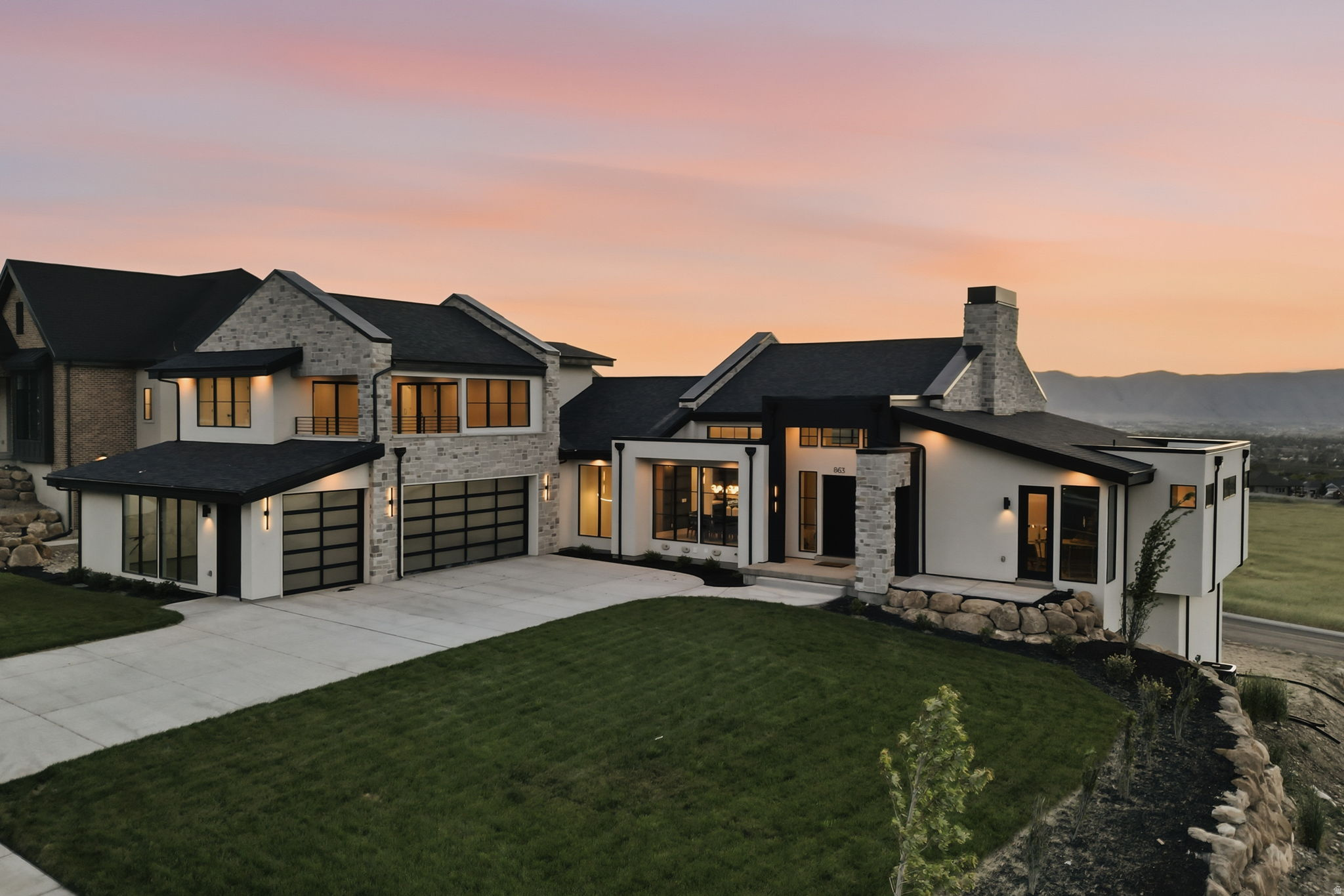 Perched in the coveted hills of Elk Ridge, this exceptional luxury residence captures unobstructed, panoramic views of Utah County, Utah Lake, and the entire valley below a setting that truly elevates everyday living. Designed for those who appreciate both refined craftsmanship and peaceful surroundings, this home offers a seamless blend of elegance, functionality, and breathtaking scenery. Inside, you'll find an open, thoughtfully designed floor plan highlighted by vaulted ceilings, expansive windows, and luxury finishes throughout. The heart of the home is built for connection and entertaining, flowing effortlessly into indooroutdoor living spaces where you can unwind on the patio beside the outdoor fireplace, all while taking in the stunning views. The main level features a private primary suite, a dedicated formal office, and beautifully appointed ensuite bedrooms, offering comfort and privacy for family and guests alike. An attached mother-in-law suite adds flexibility for multi-generational living or extended stays. Every detail has been carefully curated, from the high end tile work and custom millwork to the overall design aesthetic that creates a warm yet sophisticated atmosphere. Additional amenities include a home gym, private theater room, and a spacious 3-car garage, along with a bonus garage space perfect for storage or easily transformed into a golf simulator, batting cage, art studio, or expanded fitness area. This one-of-a-kind home is the result of a meticulous collaboration between Navy Gray Designs and DYZN Builders, known for crafting distinctive, non-replicated homes with unmatched attention to detail. Whether you're entertaining, relaxing, or simply enjoying the views, this Elk Ridge masterpiece offers a rare opportunity to experience luxury living at its finest. **Buyer is advised to obtain an independent measurement. Buyer/Buyers Agent to verify all info including sq. ft.