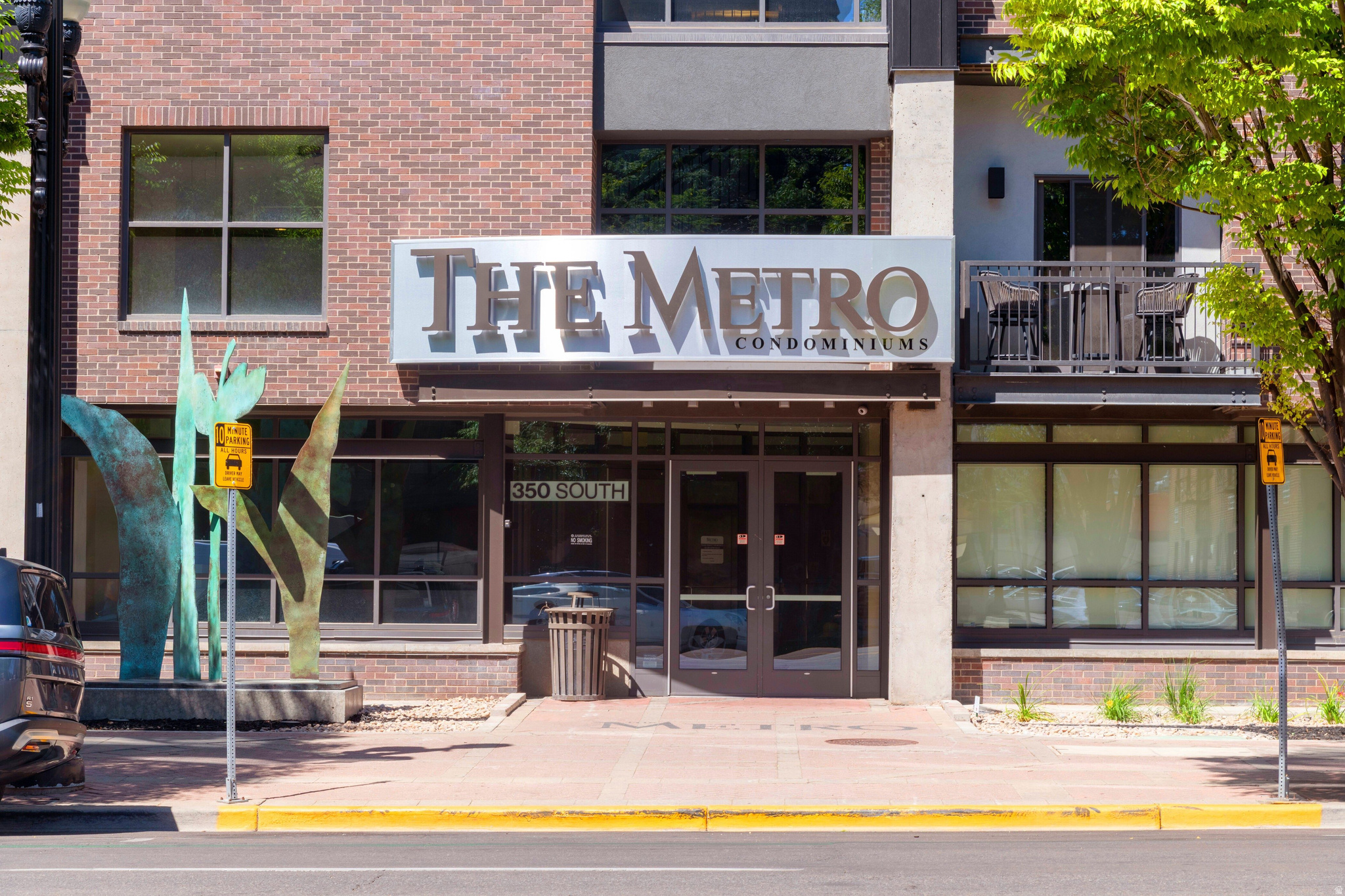 Experience elevated urban living at the Metro Condos in the heart of East Downtown. This updated condo features 9-foot ceilings, city and mountain views, and a stylish open-concept layout with a spacious kitchen and elevated bar, perfect for entertaining.  Recent move-in ready upgrades include fresh paint throughout, new carpet, $9k in custom closet systems, roller shades, plus a 65" TV with soundbar and subwoofer.  A gas fireplace and Pella windows create a charming, quiet retreat, while the spacious primary suite offers a walk-in closet and separate tub and shower.  Also included are 2 reserved parking spaces and a storage unit.  Metro is a pet friendly building with it's own Dog Park and has a Club Room, Plaza & Fitness Center.  Located one block from TRAX and minutes from I-15, you're within walking distance of Library Square, Gallivan Center, Eccles Theater, Capitol Theatre, dining, nightlife, and more.