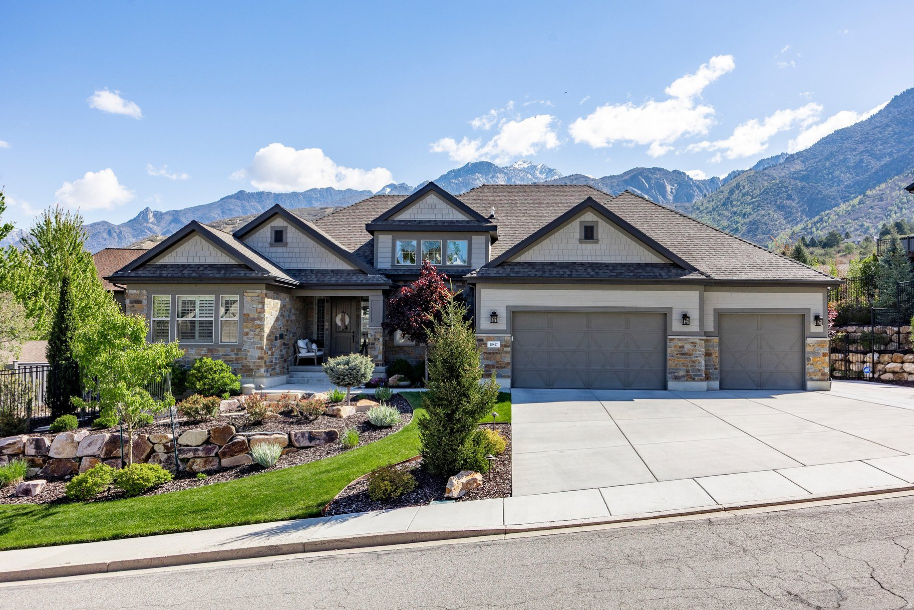 Welcome to this exceptional custom residence where thoughtful design, refined finishes, and breathtaking natural light come together to create a truly elevated living experience. From the moment you enter, soaring ceilings and an impressive wall of windows flood the home with light, seamlessly connecting the interior spaces with the beauty of the surrounding landscape. Designed for both everyday comfort and sophisticated entertaining, the home offers multiple outdoor living areas, including a covered patio, a striking outdoor gas fireplace, and a hot tub, creating the perfect setting to relax or host under the stars. At the heart of the home, the chef's kitchen blends beauty and functionality with custom cabinetry, soft-close features, an expansive walk-in pantry, and the rare convenience of dual dishwashers built into the oversized island, making entertaining effortless. Perfectly positioned on the highly desirable Sandy bench, this rambler offers unrivaled access to Utah's world-class outdoor lifestyle. Whether it's skiing, hiking, cycling, horseback riding, or peaceful neighborhood strolls, adventure is always just moments away. The home offers generous bedrooms and bathrooms, abundant storage, and thoughtfully curated details throughout, including a custom wine room and a fully equipped basement kitchenette, providing ample space to gather, unwind, and grow. No detail has been overlooked, with a long list of upgrades including an outdoor gas fireplace, hot tub, security system, on-demand hot water, MinaAire ceiling fans throughout, custom master closet, epoxy garage flooring, landscape lighting, drip irrigation and a 220V 30-amp garage outlet. This is a rare opportunity to experience luxury living in one of Sandy's most sought-after locations, where comfort, craftsmanship, and lifestyle meet.