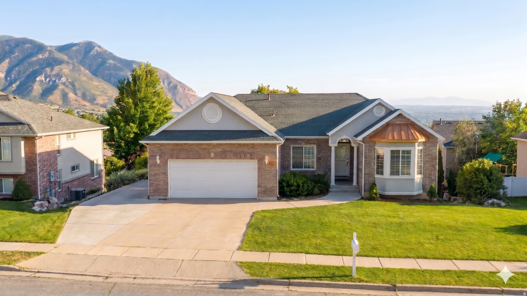 Dramatic Wasatch Mountain views, a panoramic valley overlook, and a location steps from some of the best outdoor recreation in the area - this brick home earns every superlative. The entry sets the tone immediately: etched glass front door, hardwood floors, a formal sitting room with full wainscoting and chandelier. The kitchen features granite counters, subway tile backsplash, and stainless appliances. The main living room centers on a corner gas fireplace beneath crown molding, with a picture window that frames a Wasatch valley panorama. Step out onto the covered back deck where a hot tub awaits and the Wasatch Range fills the horizon. About 100 feet away, Mountain View Park offers year-round recreation - sledding in winter, a full-size soccer field, and a front-row seat for the hundreds of 4th of July fireworks displays that fill the valley. Trailheads connecting to the Bonneville Shoreline Trail system are a few short blocks away. This is a neighborhood where outdoor living is built into daily life. Inside, the primary suite is designed for genuine retreat - soaking tub, separate walk-in shower, and double vanity. The main-floor guest bedroom (or office) has a curved bay window offering a view of Ben Lomond Peak. The finished walkout basement provides a large family room and additional bedrooms. Sustainability meets comfort - a 2022 solar panel system helps offset energy costs and reduces your carbon footprint. The two-car garage features a workbench and shelving for the hobbyist or craftsman. From the mountain views to the trail access to the hot tub at sunset - this is a home built for living well.