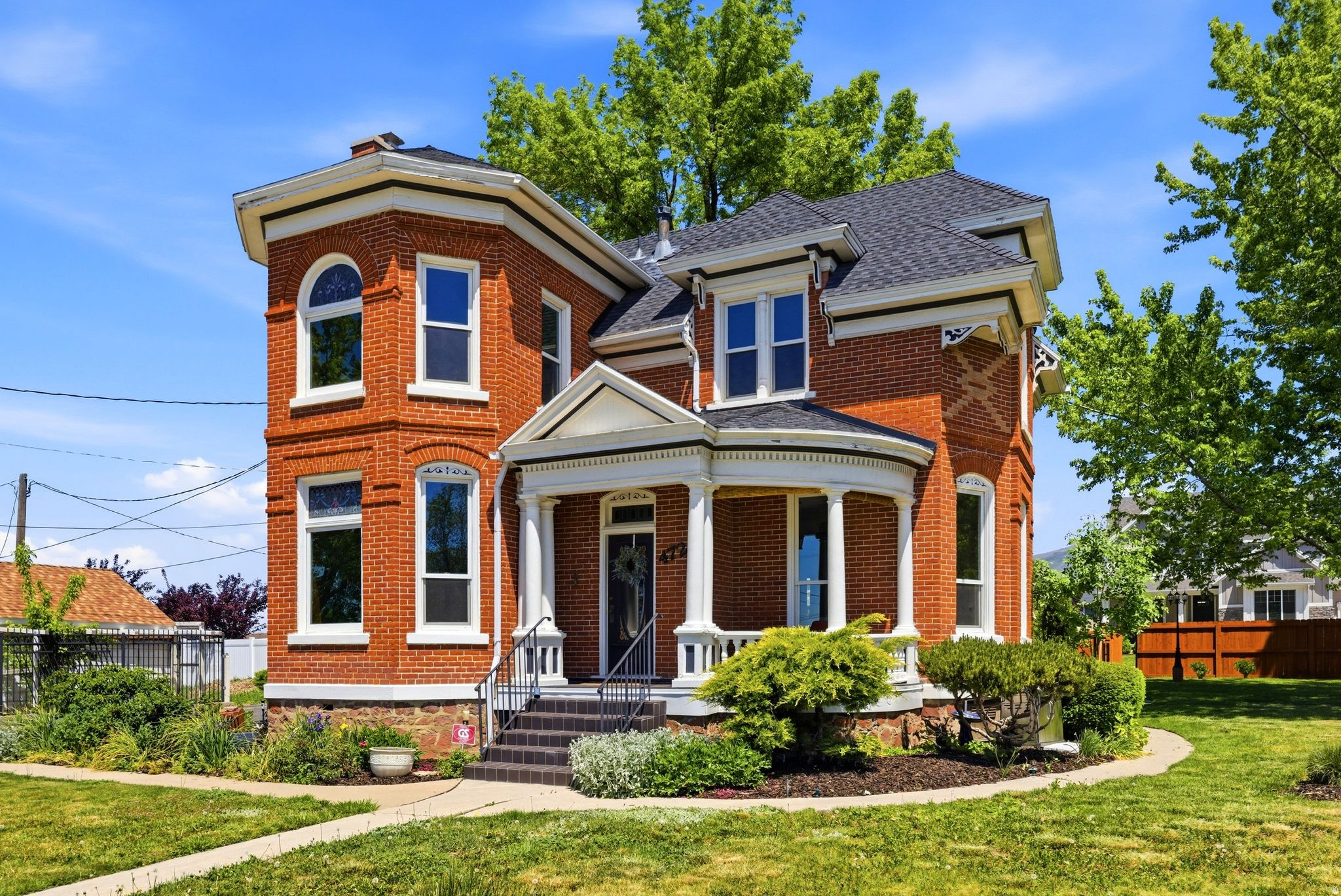 Built circa 1900 this historic home is a rare piece of living history in the heart of Kaysville. Designed by celebrated Davis County architect William Robert Allen - the same craftsman behind the Kaysville Tabernacle and Barnes Bank Building - this Victorian Eclectic brick residence commands attention with its central-block-projecting-bays design, ornate exterior detailing, and five stained glass window features. Inside, 10-foot ceilings on the main, a true parlor, push-button electrical switches (updated electrical though), two fireplaces with tiger wood, Venetian plaster up the staircase, and period lighting with ornate ceiling medallions speak to a level of craftsmanship that simply isn't built anymore. In true Victorian fashion, the kitchen lives in two intentional spaces - a butler's pantry with period sink leads into a separate cooking room anchored by a Majestic wood-burning stove converted to natural gas, preserving the rhythm of how this home was meant to be lived in.  The outdoor park like yard features an outdoor stone fireplace with patio, and a young orchard with 7 fruit trees complete this one-of-a-kind property.  Modern updates: roof 2021. Anderson windows 2023, dual furnaces & ACs, brand new water heater, updated electrical, new bathroom 2023.