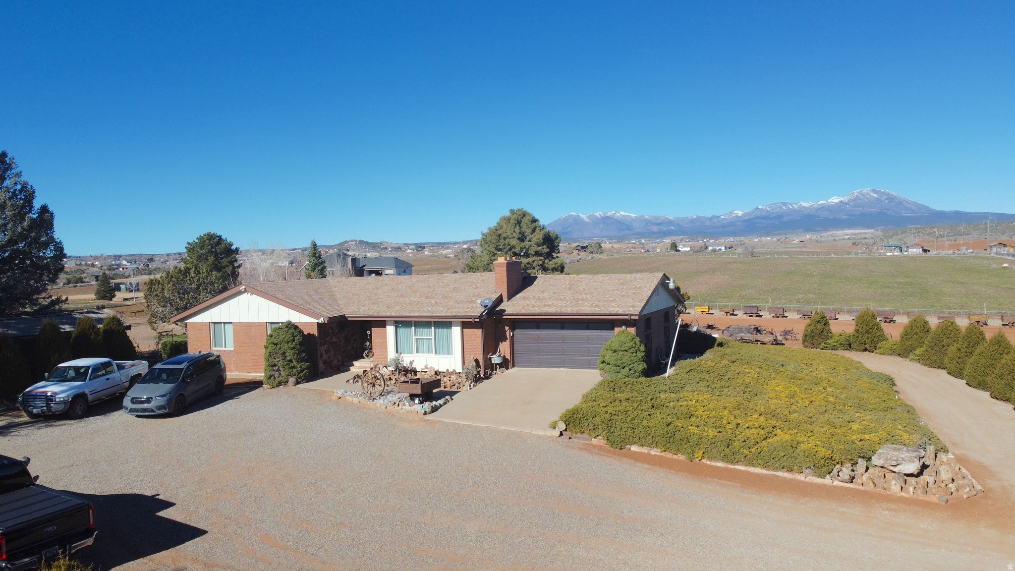 A rare find of beautifully maintained and cared for home on 4 acres of private surroundings with panoramic views of the Blue Mountains, Bears Ears and four states - offering a unique blend of space, comfort, and opportunity. Inside enjoy two kitchens, two fireplaces, central heat & air, and abundant storage throughout including a large bedroom sized cold storage room. Outside property feature highlights include an stunning artistic wagon wheel fence, beautiful duck pond (shared), fruit trees, sun deck, and multiple outbuildings  perfect for animals, hobbies, or future expansion. Easy access, quiet country living, and incredible views make this property truly unique!