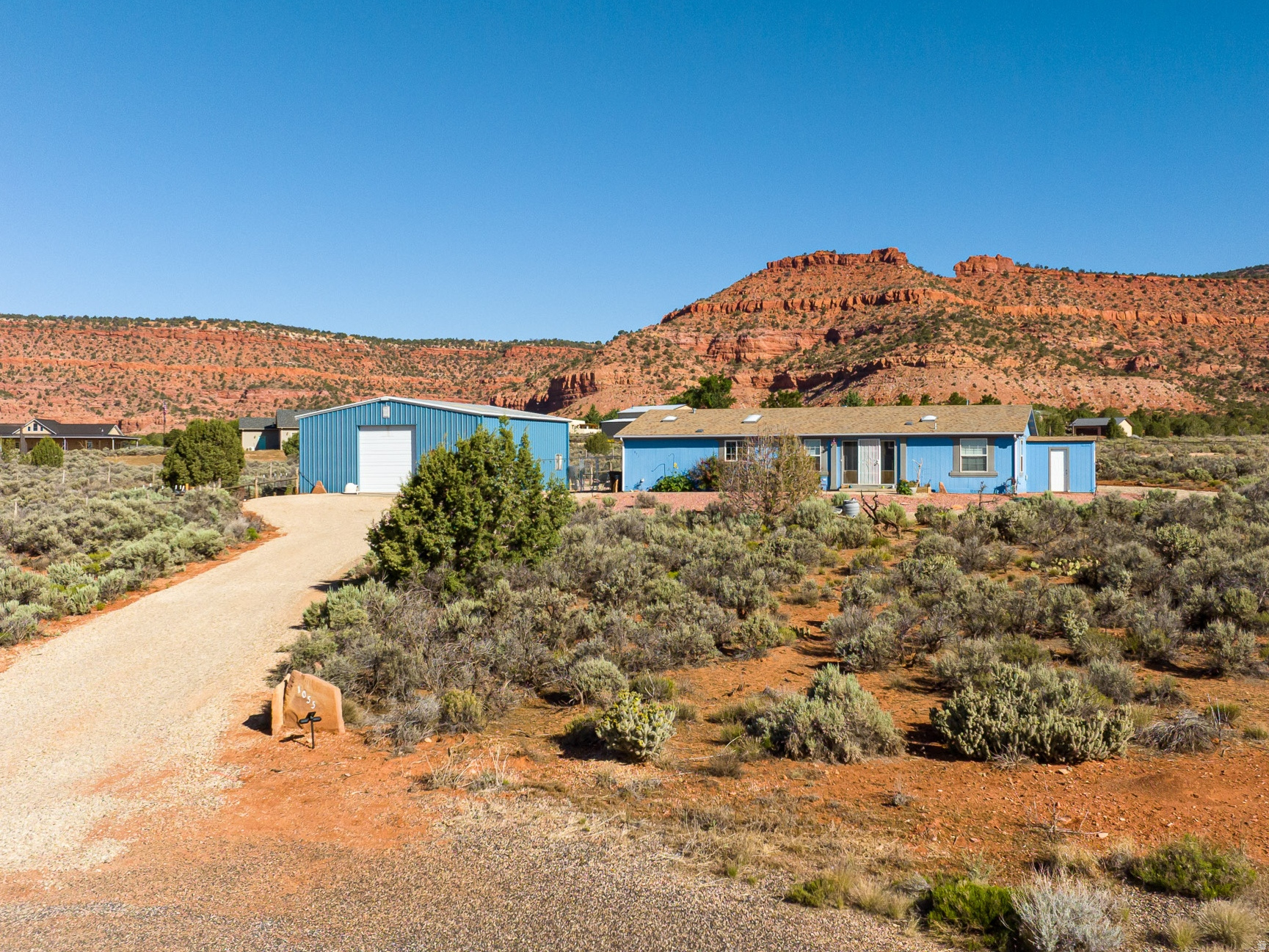 Bring your hobbies, animals, off-road vehicles, and RV- there's room for it all on this versatile 2.47 acre property! This well-maintained 3 bedroom, 2 bathroom home features a spacious floor plan with the primary suite on one side and two additional bedrooms and second bathroom on the other. The updated kitchen is designed for gathering and entertaining with granite tile countertops, a large center island, modern appliances, and an adjoining dining area. Enjoy beautiful Vermillion Cliff views and the iconic Mansard Trail from the living room, complete with a cozy wood-burning stove for supplemental heat. Hard surface laminate flooring runs throughout, and major updates including the septic system and water main to provide added peace of mind. Complete with a 40' x 36' shop (with a pull-through bay), full RV hookups, fenced area for pets, and a separate fenced garden space, this property offers the flexibility and functionality you've been looking for! Ready for your domestic animals, and livestock is also allowed with plenty of room to add a paddock, or horse corral. Experience country living with room to work, play, and grow - all surrounded by Southern Utah's stunning red rock scenery! (Buyer to verify all)