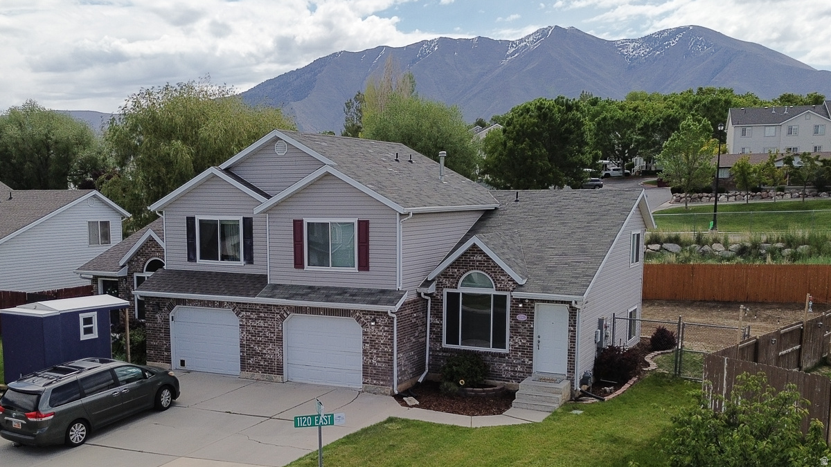 Stunning Spanish Fork twin home featuring modern updates and an expansive, private retreat! This move-in-ready residence on Lynnbrook Drive perfectly blends architectural character with functional living. Step inside to an impressive main living area defined by vaulted ceilings and a large arched picture window that floods the space with natural light. The open-concept design flows seamlessly into the kitchen, which boasts custom blue cabinetry, high-end stainless steel appliances, a central island, and stylish stained-glass-inspired lighting. The spacious master suite serves as a true sanctuary, mirroring the high-volume ceilings found in the living room and offering peaceful neighborhood views. Perhaps the most unique feature is the over-sized, fully fenced backyard. Rarely found with twin homes, this massive outdoor space provides endless possibilities for gardening, play, or creating your dream patio oasis. Located in a quiet, established neighborhood with easy access to all the amenities Spanish Fork has to offer, this home is a rare find.