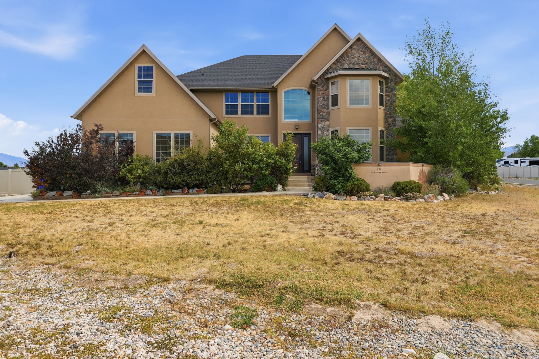 Tucked away in the coveted South Willow Ranches, this horse-zoned estate sits on just under 2/3 of an acre, offering the perfect blend of privacy, space, and endless potential. Fully fenced with drive-through gates and room to build a future detached garage, shop, or additional outbuildings, the property is ready to fit your lifestyle.  The backyard is a true private retreat, featuring mature shade trees, a fruit orchard, berry bushes, blooming roses, winding garden pathways, redwood pergolas, a gazebo, misting system, ambient landscape lighting, and breathtaking mountain views-creating an ideal setting for entertaining or simply enjoying peaceful evenings at home.  Inside, you'll find 5 spacious bedrooms, soaring 20-foot ceilings, and a stunning floor-to-ceiling stone fireplace that anchors the main living area, with French doors opening directly to the backyard oasis. The oversized main-level primary suite is its own sanctuary, complete with a three-sided fireplace, jetted soaking tub, dual vanities, oversized dual-head shower, and a generous walk-in closet.  The home has been rehabbed with an updated kitchen, new paint, and new carpet throughout. Downstairs, the framed basement offers a blank canvas ready for future expansion and includes a hidden "secret" storage/safe room-perfect for food storage, emergency supplies, a secure safe room, or whatever your imagination has in mind.  This is more than just a home... t's a rare opportunity to enjoy country-style living with room to grow, all while being close to modern conveniences.