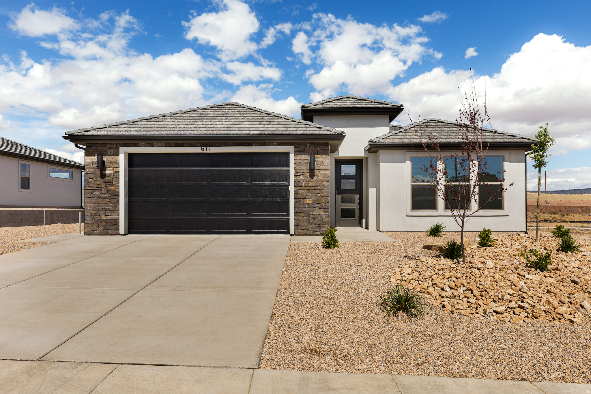 Enjoy quality craftsmanship and thoughtful design in this refined home featuring durable 2x6 exterior construction and large windows that fill the space with natural light. The open-concept great room creates the perfect gathering space to stay connected and be part of every conversation. The kitchen shines with upgraded KitchenAid appliances, a stylish tile backsplash, and soft-close cabinets. Retreat to the primary suite featuring large windows, a walk-in closet, and a zero-step entry shower for added comfort and convenience. Step outside to a covered patio ideal for relaxing or entertaining. The extended-width, fully finished garages offer ample room for vehicles, storage, and hobbies to accommodate the lifestyle of southern Utah. Residents enjoy access to an exclusive community pool and bath house, perfect for enhanced comfort where family and friends can relax and enjoy the sense of belonging. Located in the sough-after Divario community, you're just minutes from golf courses, extensive hiking and biking trails, shopping, and dining-yet surrounded by quiet serenity and breathtaking red mountain views--the balance between accessibility and escape! Please ask about available Preferred Lender incentives-and schedule your private showing today to experience this exceptional home for yourself.