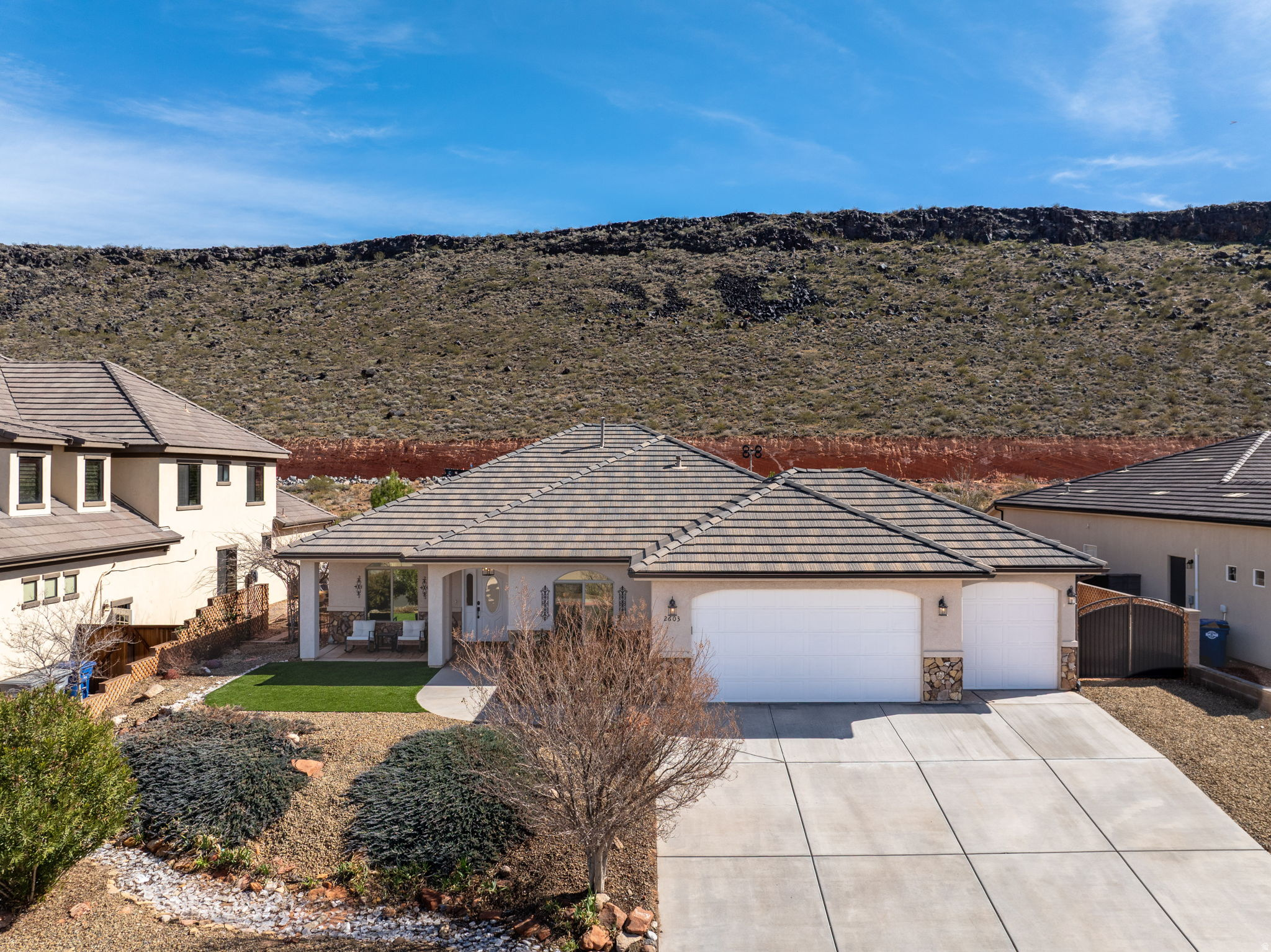 PRICE REDUCED! AIRBNB-STYLE INCOME POTENTIAL! Located in Dixie Springs just 7 minutes from Sand Hollow Lake & the dunes, this 4-bedroom home offers elevated finishes, flexible living space, & beautiful mountain views while backing to a stunning natural hillside. Layout includes a versatile bonus/flex space ideal for a home office, gym, media room, or hobby area. Enclosed 3rd-car bay has been transformed into a private guest-style retreat with separate living potential, creating an ideal setup for owner-occupied Airbnb-style income, multigenerational living, guests, workspace, or flex use (buyer to verify total sf & all local rental regulations & permitted use/SF - Additional 312sf +5th bedroom/1 bathroom in 3rd car bay are incorporated into the total SF of home). Open kitchen features quartz countertops, a large contrasting island, white cabinetry w/crown detail, updated pendant lighting, black hardware & fixtures, pantry storage & stainless appliances. Living room centers around a fireplace with built-ins and flows seamlessly into the dining area w/abundant natural light. Primary suite offers a spacious walk-in closet and an upgraded bath w/dual vanities, quartz counters, matte black fixtures, custom cabinetry storage, and a beautifully tiled walk-in shower w/bench seating. Backyard is a true highlight - professionally designed with artificial turf, mature palms, a tranquil rock water feature w/fountain, gazebo seating area & multiple entertaining spaces. Backing and siding natural hillside, the property provides exceptional privacy along w/expansive desert & mountain views that are difficult to find in this price range. Located on Dixie Power and positioned near boating, golfing, off-roading, hiking & all the recreation Sand Hollow is known for, this home offers comfort, flexibility, and lifestyle in one of Southern Utah's most desirable neighborhoods. 3rd car garage modified to a bonus flex room w/bathroom- not included in square footage.