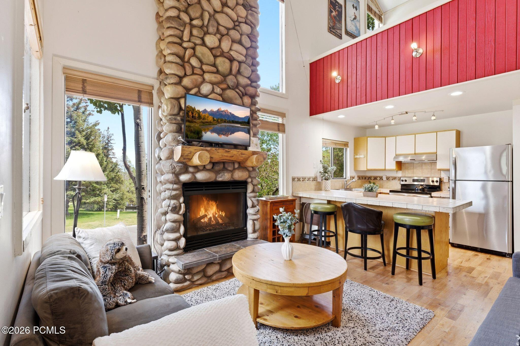 Arguably one of the best-located and most desirable Three Kings condos in Park City. This light-filled end unit offers exceptional flexibility as a nightly-rentable investment, second home, or full-time residence--just a short walk to Park City Mountain Resort and steps from the free bus route to Deer Valley and Historic Main Street. The thoughtfully designed floor plan features an entry-level bedroom, two bathrooms, a dedicated laundry area, and an upstairs loft-style primary suite with adjacent private sauna. The open living space is anchored by a river rock fireplace and opens to a private deck with BBQ, overlooking open space and the Park City Golf Course. Surrounded by mature trees and beautifully maintained grounds, residents enjoy access to the Three Kings Clubhouse with heated pool, hot tub, sauna, gym with a Peloton bike, game room, lounge areas, and locker facilities. Additional features include one reserved underground parking space, one guest parking pass, bike storage, and ski storage. Nightly rentals and pets are permitted (with restrictions). The quarterly HOA covers water, sewer, garbage, basic cable, snow removal, exterior building maintenance, and common area upkeep. Offered fully furnished, as- is, and turn-key for immediate occupancy.