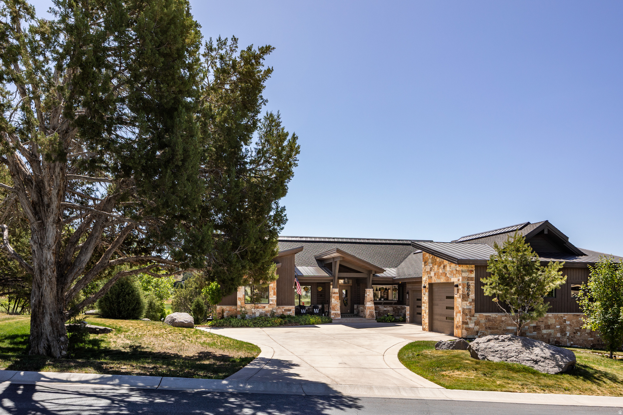 686 Red Mountain Court, also known as 'The Juniper House,' offers exceptional craftsmanship, elevated mountain living, and luxury amenities already integrated throughout the home. A Full Golf Membership is available for purchase. Designed for gathering and making memories in every season, this spacious retreat comfortably sleeps 22 guests and was built to host holidays, summer weekends, and multi-generational living. The main level features two private primary suites--each with king-sized accommodations, ensuite baths with oversized soaking tubs and walk-in showers, walk-in closets, electric blinds, built-in reading lights, TVs, and direct deck access. The heart of the home includes a well-appointed kitchen, generous dining space with farmhouse-inspired finishes, and accordion glass doors opening to an expansive east-facing deck with a built-in Weber grill. The great room showcases vaulted ceilings, rustic beams, a custom stone fireplace, oversized windows with golf course and wildlife views, built-in speakers, and an 80-inch TV. The oversized 3-car garage includes epoxy flooring, built-ins, overhead storage, EV charging, and organized gear space. Outside, the flat, fully landscaped homesite offers lawn, mature landscaping, irrigation, abundant parking, and a quiet cul-de-sac setting with signature Red Ledges views. The walkout lower level provides privacy and recreation with three additional bedrooms, including an oversized bunk room for large groups. A second family room features a fireplace, TV, kitchenette, beverage fridge, and flexible workspace. The game room--with dedicated Wi-Fi and climate control--offers endless entertainment or can be reimagined as a theater or office. Outdoor living continues with a recently upgraded patio, new hot tub (2025), gas firepit, forested privacy, and a peaceful creek. The owners are relocating out of state and hope the next family enjoys this special home as much as they have.