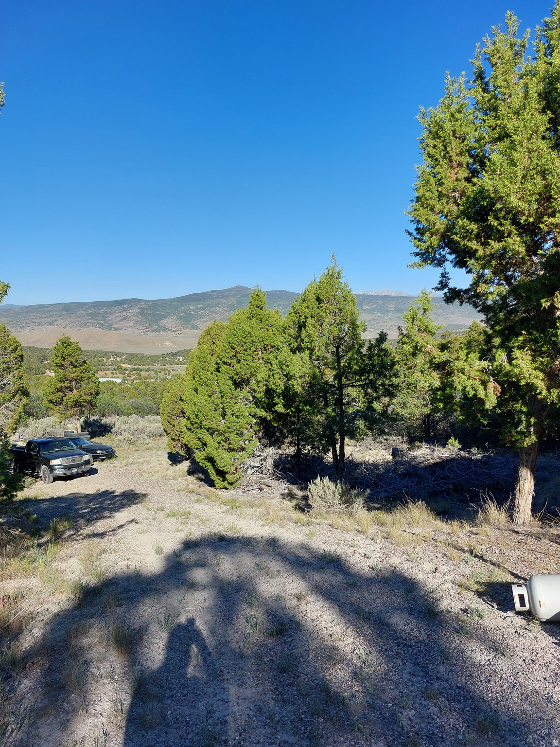 Year round access 5.8-acre property with a camp trailer, pole barn, and 12' x 18' covered storage. Features an established camping area with a fire pit and stone terracing. No HOA restrictions, making it perfect for building, homesteading, or recreation.