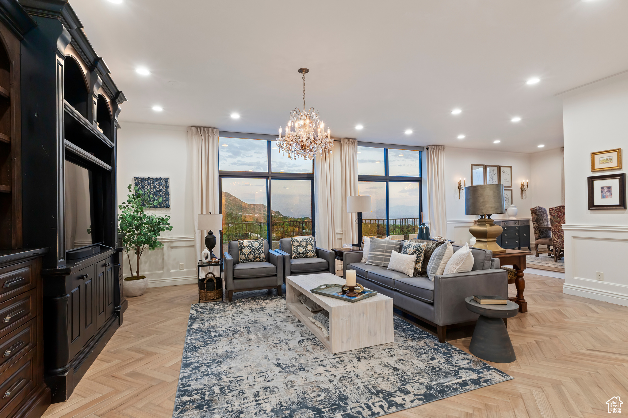 $100,000 price correction, Just in time for your summer move!!!!!   Timeless. Inviting. Functional. Elegant.  Set high above the city with park, mountain, and skyline views, this extraordinary penthouse combines classic design, elevated comfort, and cosmopolitan ease. From the marble-inlaid foyer to the floor-to-ceiling windows, every detail reflects thoughtful craftsmanship and enduring style.  The living and dining spaces are wrapped in glass, immersing you in Utah's natural beauty. Crisp architectural lines, warm wood finishes, and artful lighting fixtures establish a refined yet welcoming tone. At the heart of the home, the kitchen balances sculptural beauty with exceptional function: custom cabinetry, a rift-cut white oak island topped with leathered Taj Mahal quartzite, and seamlessly integrated Wolf and Sub-Zero appliances. Gold-tone hardware and hand-forged refrigerator handles bring artisan character into daily use, while a luminous marble backsplash glimmers like a constellation.  Private spaces are equally considered. A den, tucked behind 18th-century carved Balinese doors, offers intimacy and character. The primary suite is a true retreat, with glass walls framing mountains, lake, and city lights. A fireside sitting area, spa-inspired marble bath, and dual, cedar-lined walk-in closets complete the sanctuary.  This is more than a home, it's a mountain-framed haven where every hour reveals something beautiful anew.
