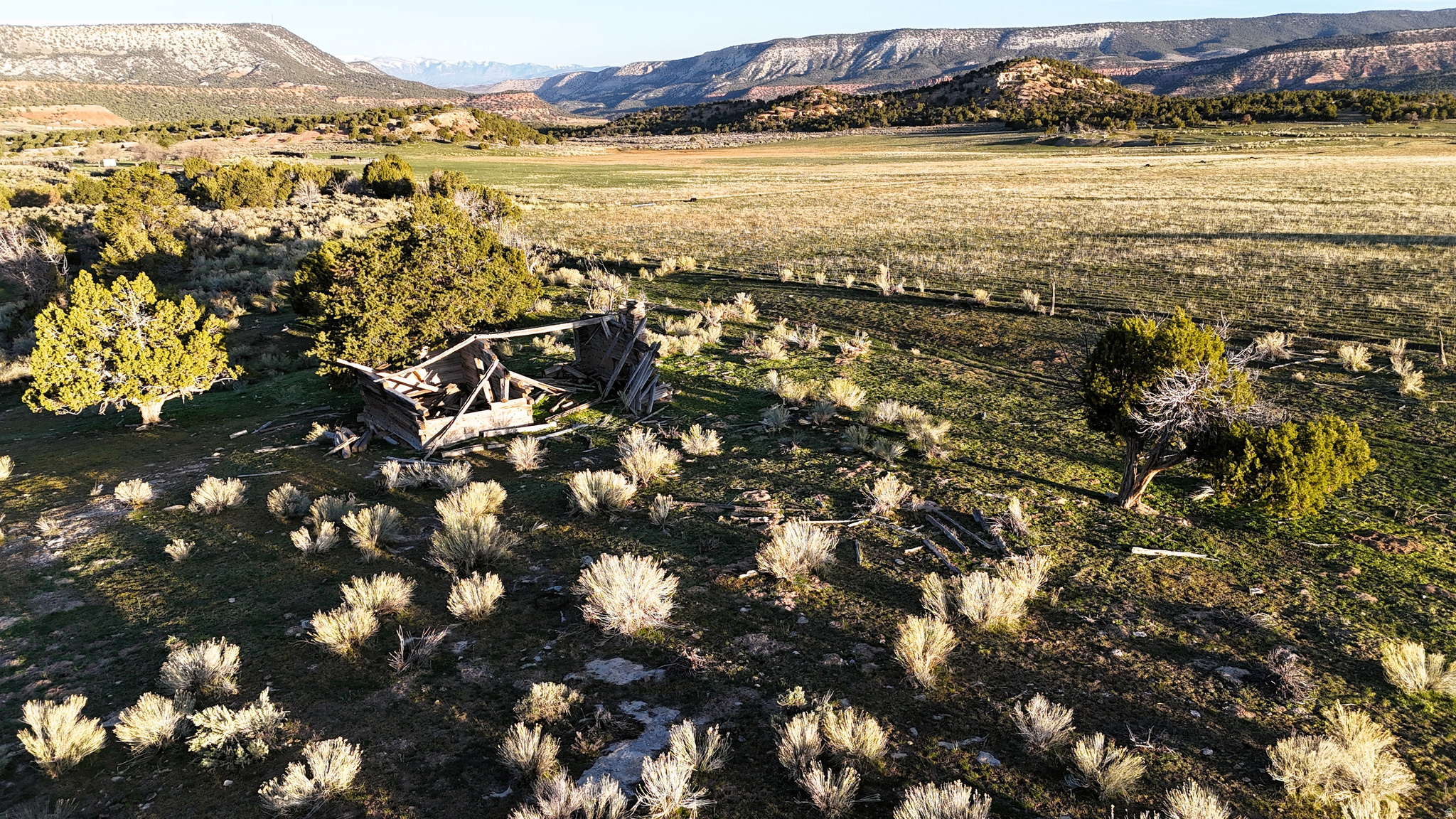 This 190-acre property in Sevier County, Utah, offers a mix of productive meadows, wooded terrain, and natural water sources in a setting adjacent to public land. Located near the gateway to Fishlake National Forest, the parcel sits along the slopes of Oak Ridge and lies approximately one mile from paved Gooseberry Road with convenient access to Interstate 70. The property has been held by the same family for generations and reflects a long history of careful stewardship. Historically, portions of the land were cultivated as productive farmland after the area was first homesteaded in the late 1800s. While large-scale farming is no longer active, the soils, layout, and infrastructure remain, offering opportunities for agricultural use such as grazing or small-scale farming operations. Approximately 100 acres consist of semi-irrigated meadow ground that has historically supported grazing livestock. These meadows provide open terrain with established grasses suitable for seasonal grazing. A gravity-fed irrigation system helps distribute water across portions of the meadow, making use of natural water sources on the property. Several springs flow on and through the parcel, providing water for livestock as well as habitat for wildlife that frequent the area. The property also supports a diverse wildlife presence. Elk, mule deer, wild turkey, and other species are commonly found in this region of central Utah. The parcel currently qualifies for two cow elk depredation tags each year, with the possibility of obtaining additional tags through the Utah Division of Wildlife Resources, according to current regulations. Because the land is bordered on three sides by national forest land, wildlife movement through the area is common. Roughly 70 acres of the property consist of sagebrush terrain and pinyon juniper woodland. These wooded sections are primarily located on the northeastern and southern portions of the parcel. The vegetation provides cover and habitat for wildlife while also creating natural separation across the property. The mix of open meadow and wooded terrain supports a variety of potential land uses. With its size and layout, the property may offer several potential building locations for a residence, cabin, or seasonal retreat, subject to local regulations and permitting. Elevated areas on the property provide views of the surrounding mountains and nearby public lands. The surrounding national forest creates a setting with limited nearby development and convenient access to outdoor recreation. Recreation opportunities in the area include hunting, hiking, horseback riding, and exploring the extensive road and trail systems within Fishlake National Forest. The nearby Gooseberry Road corridor also connects to regional travel routes, making it possible to reach the property while still maintaining a rural setting. Nearby communities include the town of Salina, which provides basic services and amenities, and the city of Richfield, a regional hub offering grocery stores, lodging, medical services, and additional retail. The property's location near Interstate 70 allows access from multiple parts of the state. The combination of meadow ground, wooded habitat, natural water sources, and proximity to public land makes this parcel well-suited for agricultural use, recreation, wildlife habitat, or a private retreat setting. Buyers should verify zoning, water rights, grazing potential, and development options with Sevier County and other appropriate agencies.