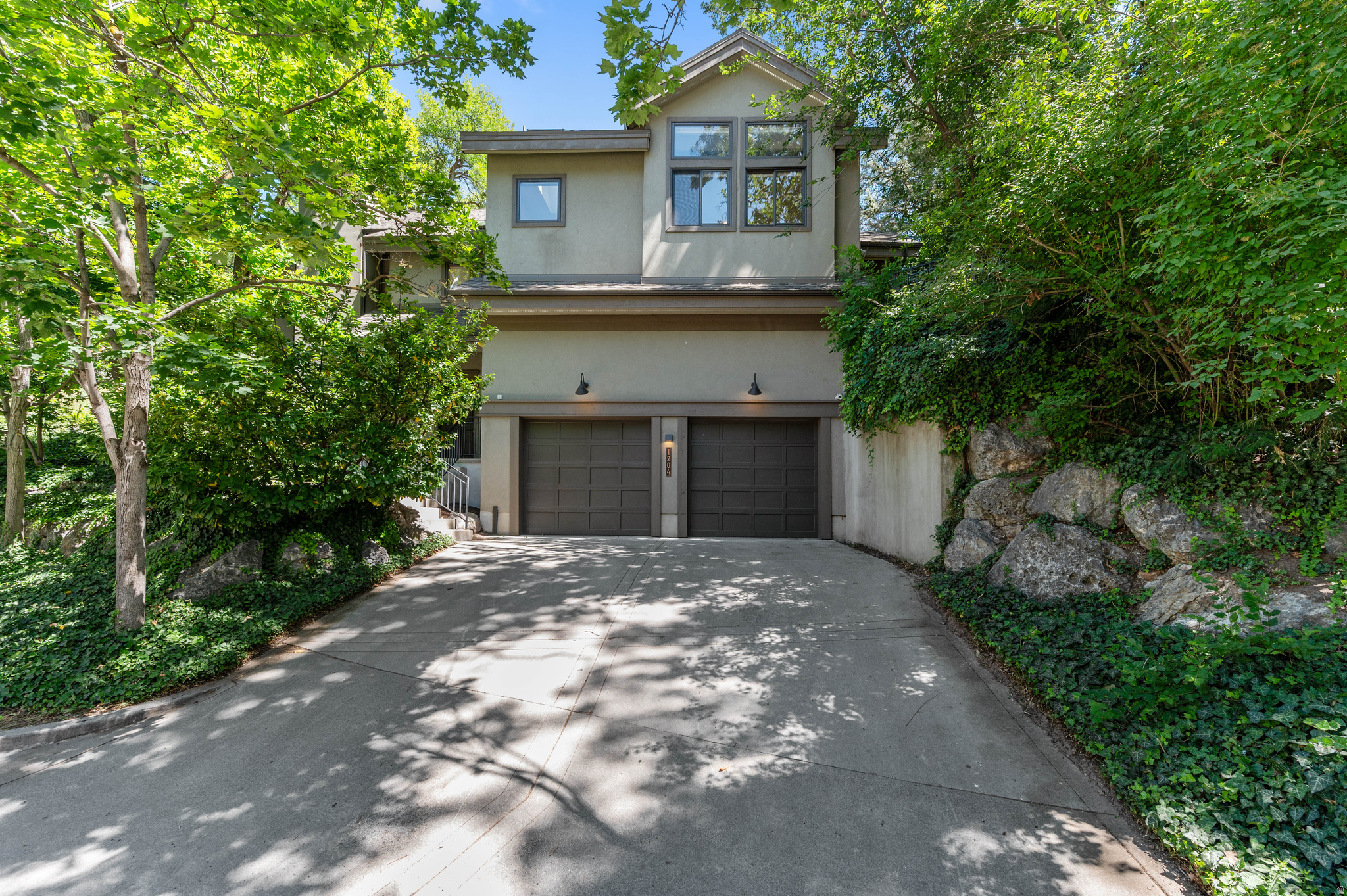 This fully renovated home in historic Gilmer Park is just blocks from 9th & 9th, but feels like a mountain retreat. Mature trees surround the property, giving it a quiet, private setting. Vaulted ceilings with exposed wood trusses run through the main living space, above new oak wood floors. Solid wood doors, wood windows and custom trim carry through the home. The kitchen is custom walnut with a gas cooktop, a built-in JennAir refrigerator, generous counter space, and a separate prep area. A wet bar on the main floor adds extra flexibility for entertaining. Two gas fireplaces and 3-zone radiant heated floors warm the home in winter, with forced-air A/C for summer, and solar panels keep electric bills low. The primary suite is spacious, with a large walk in closet, wool carpeting, power blackout shades, and direct access to a covered patio. In back, a shaded deck sits beneath a canopy of trees, perfect for relaxing or outdoor cooking. The home also includes an attached two car garage and an extra 300 square feet of storage not included in the listed square footage. Owner/Agent