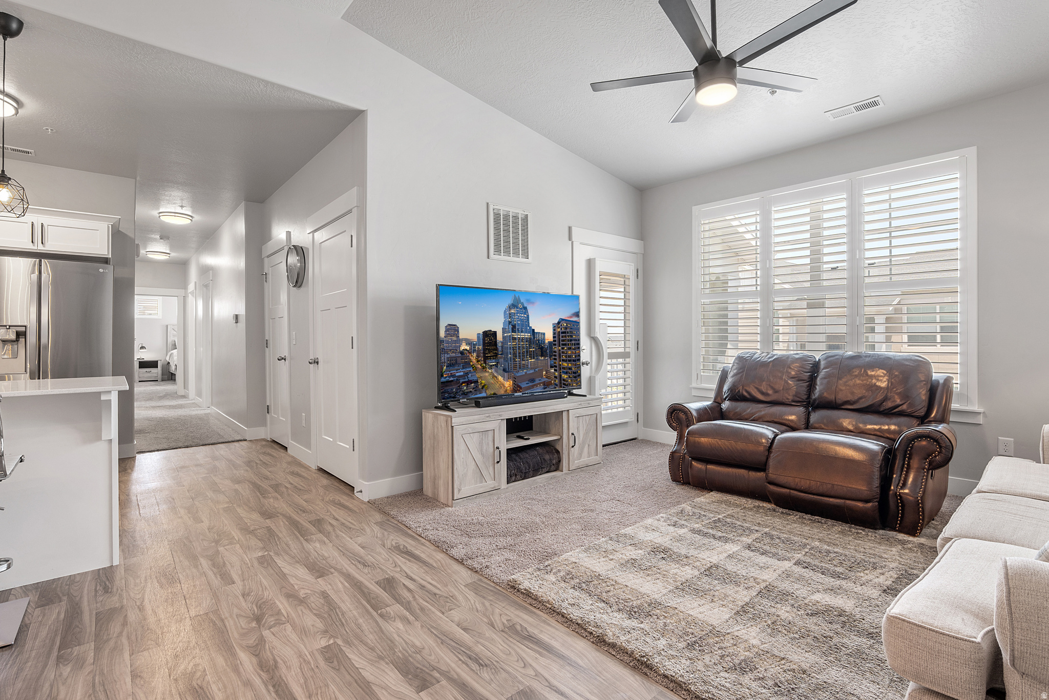 This move-in-ready, top-level condo is an incredible value with 3 bedrooms, 2 bathrooms, a private one-car garage, and an extra driveway parking spot. Enjoy the perks of being on the top floor-vaulted ceilings in both the living room and primary suite, no upstairs neighbors, and an abundance of natural light throughout. The open-concept layout features luxury vinyl wood flooring, tall plantation shutters, and a stylish kitchen with white quartz countertops, stainless steel appliances, designer pendant lighting, and crisp white cabinetry. The spacious primary suite offers a large walk-in closet and a private bath with an extended vanity and a separate tub/shower enclosure. You'll also appreciate the full-size laundry room, generous balcony space for BBQs and outdoor dining, and a well-maintained, like-new condition that means fewer maintenance worries for years to come. Located in the desirable Saddlebrook Condo community, you'll enjoy access to a pool, playground, basketball court, and peaceful surroundings-all just minutes from Mountain View Corridor, Bangerter Highway, and the rapidly expanding Mountain View Village. You're within walking distance of the future SLCC and U of U campus, the RSL Academy, a new Lee's Marketplace, and a nearby park and trailhead just half a block away. Whether you're a first-time buyer or investor (yes, the HOA allows long-term rentals!), this home checks all the boxes.   Square footage figures are provided as a courtesy estimate only and were obtained from county records.  Buyer is advised to obtain an independent measurement.