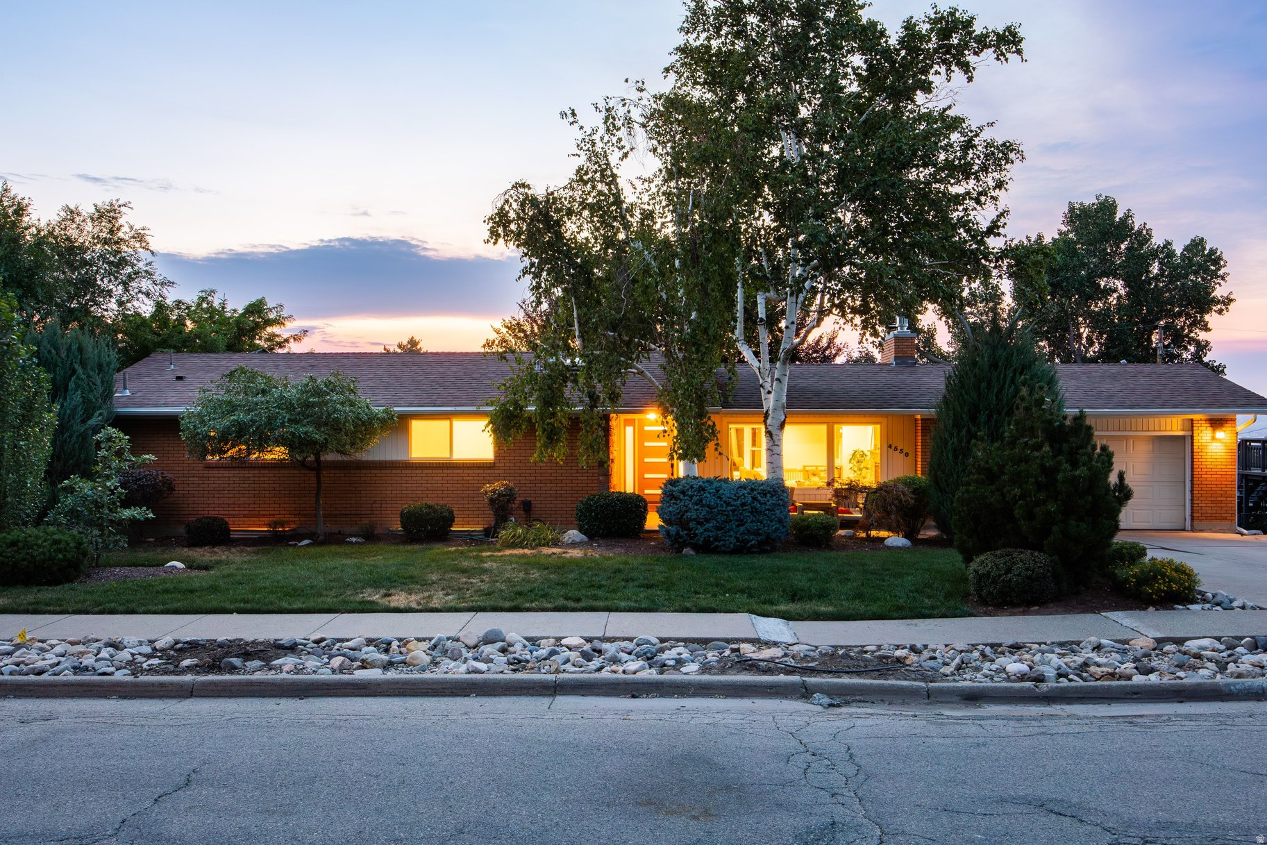 Located in the highly sought-after Olympus Cove, welcome home to 4550 Brockbank Drive. This spacious rambler-style home has beautiful updates throughout. The welcoming entry features a recently added white oak mud area with a built-in bench and cubbies. Recent renovations include new luxury vinyl plank flooring throughout the living areas, updated casing, fresh paint, top-down bottom-up blinds, and lights with remote control capability. Additional updates provide peace of mind, including a new air conditioner, replaced main water line, and water filter in 2025, and a tankless water heater and softener in 2026. The main level of this home showcases a generous living room anchored by a classic stone fireplace with gas insert, and expansive windows that fill the home with natural light. The kitchen features granite countertops, a built-in island, and opens directly to the back deck, creating an ideal space for grilling right off the kitchen. The main-level primary suite provides a peaceful retreat with a walk-in closet and an en-suite bathroom. On the lower level, the bright daylight basement expands the home's living space with a family room featuring newer built-ins and a wet bar for entertaining inside or on the expansive lower deck. The rear deck comfortably accommodates outdoor lounge and dining furniture, creating the perfect setting to relax, entertain, or enjoy a meal surrounded by the peaceful backyard setting. The beautifully landscaped yard features a serene, lush landscape, mature greenery, and a stunning beech shade tree that provides a natural gathering place during the warmer months. The grassy yard offers plenty of space for play, pets, gardening, or simply enjoying the privacy and tranquility of this exceptional Olympus Cove setting. Ideally located just minutes from Neff's and Millcreek Canyons, this home offers easy access to outdoor recreation, Olympus Cove shopping, and local dining favorites including Beaumont and Gary's. Enjoy nearby Fortuna Park with its large shaded playground, community gathering spaces, and dog meetups. Conveniently located near the amenities of downtown Holladay and Salt Lake City, with quick freeway access to Salt Lake International Airport and the world-renowned Big and Little Cottonwood Canyons for skiing, hiking, and biking. Located within a desirable school district and one of the Wasatch Front's most sought-after neighborhoods, this exceptional home offers a rare combination of comfort, convenience, and natural beauty.