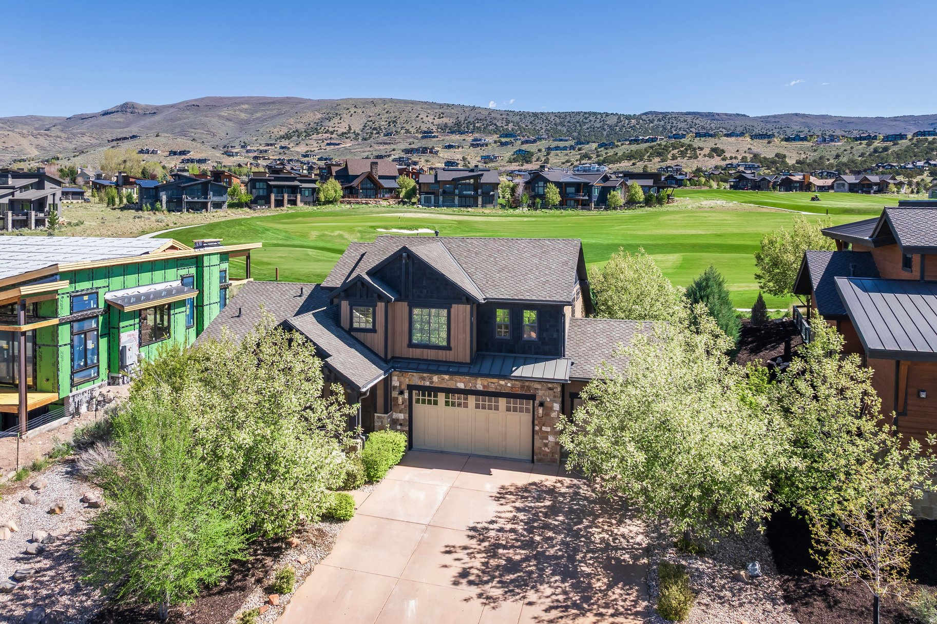 Set along the golf course with a golf membership available, this exceptional Red Ledges home offers a rare combination of convenience, privacy, and refined mountain living within the gated community. Located near the Village Center, wellness campus, fitness facilities, grill, and clubhouse, the home provides both accessibility and a peaceful residential setting. Designed for comfort and connection, the home features five bedrooms plus an office, including a main-level primary suite that supports effortless single-level living. Upstairs, two en-suite bedrooms provide privacy for family and guests, while the fully finished lower level includes two bedrooms, one configured as a bunk room, along with a spacious family room with wet bar, ideal for entertaining or relaxing after a day on the course. The oversized three-car garage provides generous space for vehicles, storage, and mountain recreation gear. Large windows invite natural light throughout and frame the surrounding landscape, reinforcing the home's connection to Red Ledges' scenic setting. Golf membership is available, providing access to the acclaimed Jack Nicklaus Signature Course and the community's exceptional four-season amenities, all within approximately 20 minutes of Park City and 45 minutes from Salt Lake City International Airport. Set within nearly 2,000 acres of thoughtfully preserved Utah landscape, Red Ledges is celebrated for its recreation-rich lifestyle, expansive open space, and year-round adventure.
