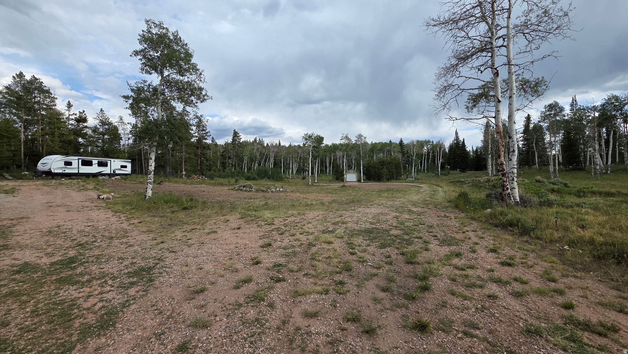 The possibilities are endless on this exceptional mountain property! Tucked away from the road, down a private driveway, this level lot offers a perfect place to host friends and family for a weekend of mountain adventures.  Already improved with water, power, septic, and three dedicated RV spots, and a 12'x32' lofted garage. you can begin enjoying this property immediately.  Whether you need a family camping retreat, a place to build your dream cabin, or just a wide-open space where the kids can ride ATVs, this property provides. Located in the gated Uinta Lands community, you'll enjoy easy access to the community fishing pond and shooting range. And, of course, the Uinta Mountains, with miles of trails, fishing, hiking, and endless outdoor recreation just minutes from the property.