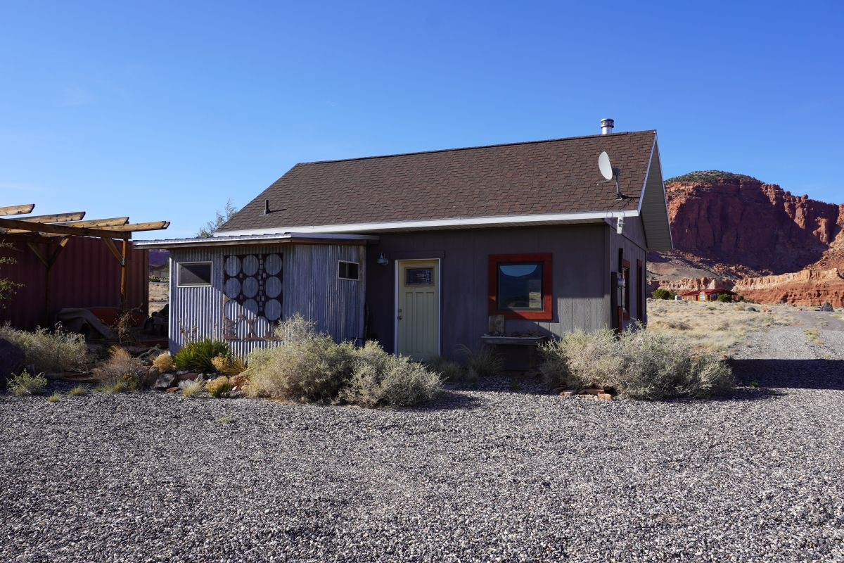 Wonderful in its simplicity and diversity, this Sleeping Rainbow property can be used in many different ways. Perfectly comfortable and enjoyable as it is, the cabin works well as a recreational retreat. Delightful with outstanding views and lovely outdoor space, and with this 2.37-acre lot, there is room to expand. If an owner chooses, more square footage could be added to the current structure, or it is possible to build another home and keep this one as a guest house. The 538 square foot cabin has ideally spaced and sized windows for the marvelous views. A wood burning stove and electric wall heaters sufficiently heat both rooms. A sizeable sleeping loft is included in the square footage. A Conex container placed on the west serves as storage and a wind break, and frames the pleasurable outdoor sitting area. The large lot affords a nice sense of space and privacy. It is stupendous in summer and fall. Close to miles of public lands for terrific hiking. Within walking distance to Torrey's Main St.