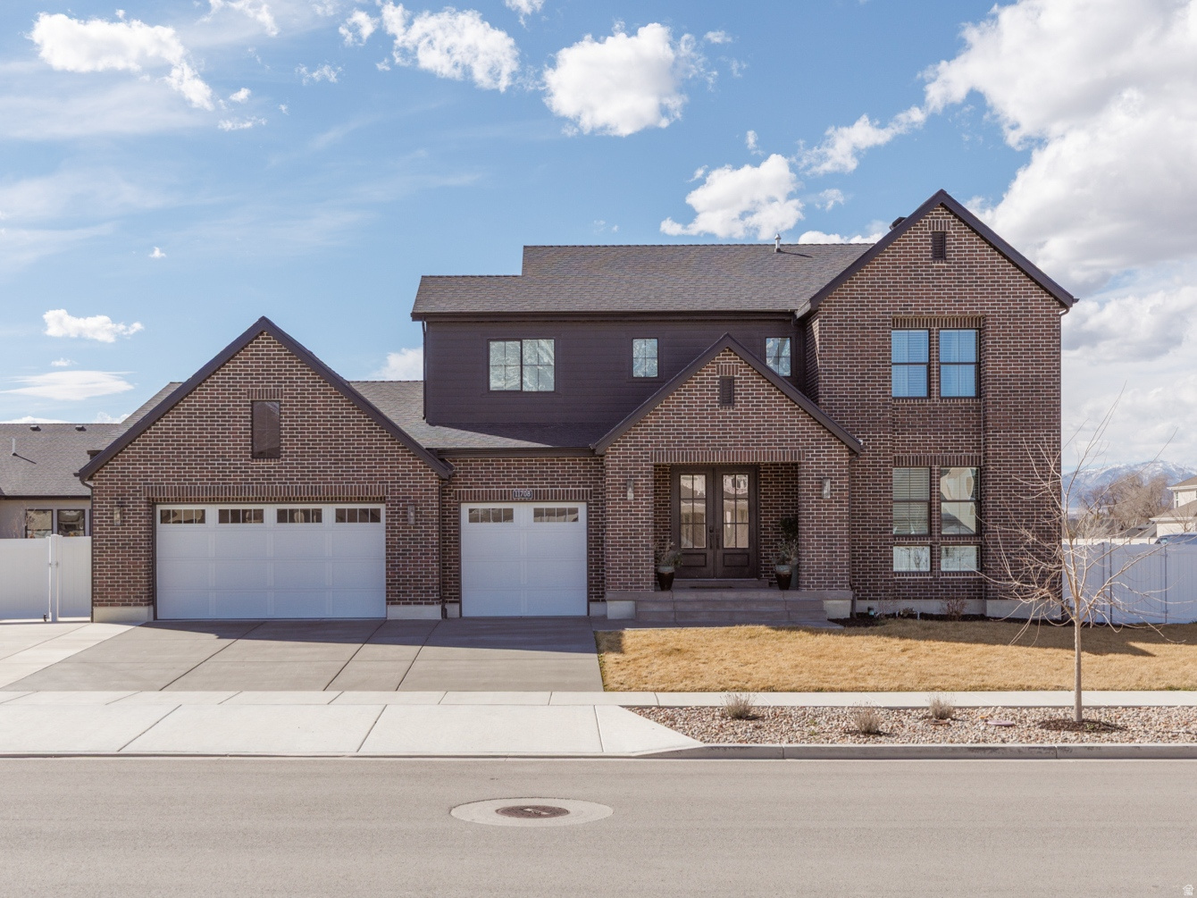 This striking 5,200-square-foot home is truly market-ready, offering confidence and peace of mind with a COMPLETED home inspection report available for your review. With classic red brick, contemporary black trim, and clean architectural lines, it makes an immediate and lasting impression.  Inside, natural light pours through dramatic two-story vaulted ceilings, creating a bright, open atmosphere throughout. The chef-inspired kitchen features custom black walnut cabinetry, granite countertops, a gas range, double ovens, and stainless steel appliances-perfectly suited for both everyday living and effortless entertaining.  The thoughtfully designed main floor includes a private office and an oversized primary suite that serves as a true retreat. Upstairs, a versatile loft provides additional living space alongside two spacious bedrooms.  The finished basement, complete with desirable 9-foot ceilings, offers additional bedrooms and a large flex area ideal for a home theater, fitness room, or game room-with room to add a kitchenette for even greater flexibility.  Designed with comfort and efficiency in mind, the home includes three furnaces for zoned climate control, a spacious three-car garage, and a dedicated RV pad for extra parking and storage.  Step outside to a fully landscaped backyard featuring a pergola just off the back deck-an inviting extension of the home, perfect for relaxing or entertaining.  Located in a sought-after, quiet community with creekside walking paths and close to Jensen Farm Park, the home is also near private schools and offers quick access to I-15 and surrounding amenities.  Meticulously maintained, thoroughly prepared, and truly move-in ready, this home offers the perfect blend of statement-making style and everyday functionality in a highly desirable location.