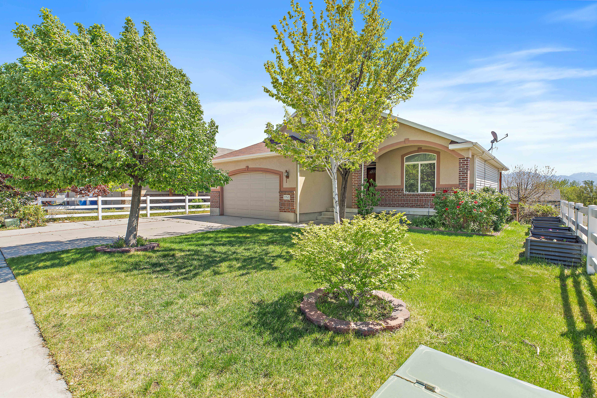 Welcome to 5763 Stone Bluff Way. This wonderful home features an open floor plan with a spacious great room, beautiful hardwood flooring, and abundant natural light, creating a warm and welcoming atmosphere. The kitchen features an open concept, beautiful knotty alder cabinets, a small island, quartz countertops, stainless-steel appliances, and a refrigerator that stays! The primary suite offers an ensuite bathroom with a separate tub and shower for added comfort, a large walk-in closet, and a large double-sink vanity. In the basement, you have a walk-out entrance with a concrete walkway to the front of the home, a large family room, and two large bedrooms with a full bathroom. The location for a future kitchen is plumbed with a working sink. In the mechanical room your will find a new $25k HVAC system with a high-efficiency air filtration system, along with the water heater and water softener, and adjacent to the mechanical room, you have a large cold storage room with abundant steel shelving. A fully fenced yard with a large TuffShed and mature trees completes the backyard. Conveniently located near shopping, dining, Oquirrh Park, the Triplex Baseball Fields, Kearns Oquirrh Fitness & Recreation Center, and more. It has everything. Come see it!  Go here for a photo tour of the home: https://unbranded.visithome.ai/aw9Bh8PxSzCQXBqVNSoDC6?mu=ft