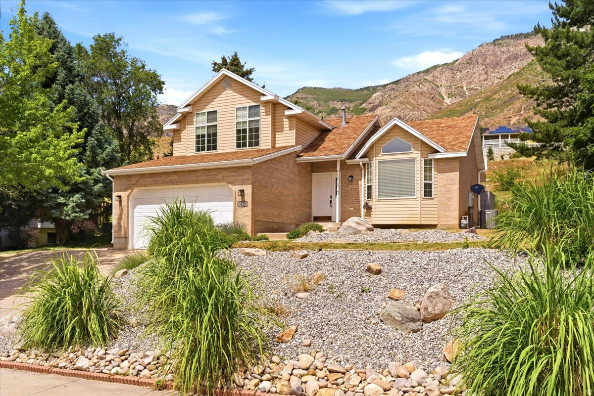 Enjoy million-dollar views without the million-dollar price tag. Perched high on the North Ogden foothills, this well maintained home offers breathtaking mountain and valley views from nearly every angle. Thoughtful updates include modern paint tones, updated flooring, a remodeled primary bathroom featuring a stylish euro-glass shower and the furnace, A/C, and water softener were all replaced in 2023. The spacious primary suite serves as a private retreat, complete with a walkout balcony where you can unwind and take in the spectacular scenery. Large windows throughout the home fill the interior with natural light while showcasing the stunning surroundings. The unfinished basement provides an excellent opportunity to expand and customize the home to fit your needs, whether you're envisioning additional bedrooms, a theater room, home gym, craft space, or playroom. Step outside to the expansive Trex deck just off the kitchen; an ideal setting for entertaining, outdoor dining, or simply enjoying the privacy and remarkable views. With no direct rear neighbors, you'll appreciate the peaceful setting and added sense of seclusion. Conveniently located just minutes from downtown North Ogden and the North Ogden Divide, you'll enjoy quick access to Ogden Valley, home to three world-class ski resorts, Pineview Reservoir, endless hiking and mountain biking trails, and year-round outdoor recreation. Don't miss this exceptional opportunity to own a home where comfort, privacy, and breathtaking views come together.