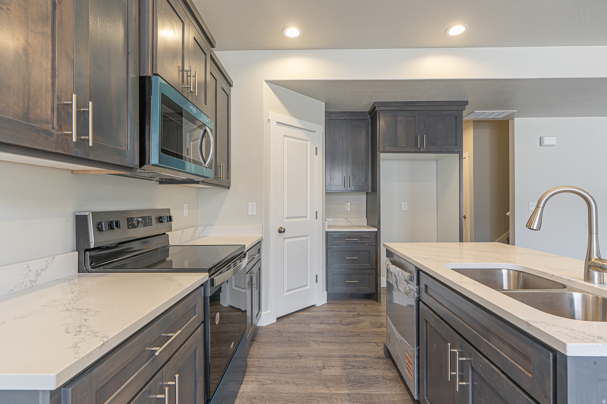 Move-in ready townhome featuring rich stained cabinetry, quartz countertops, two-tone paint, and a spacious primary suite with tray ceiling. Thoughtfully designed with warmth, character, and functional living spaces throughout. Enjoy the convenience of low-maintenance living without sacrificing the feeling of home.