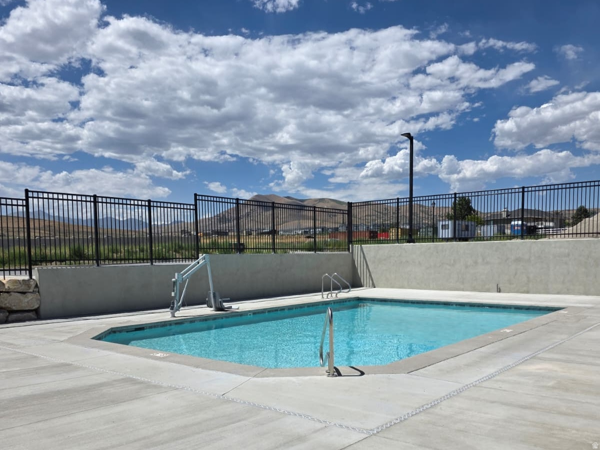 MOVE IN READY! POOL VIEW! Be among the first to call Saratoga View home-an active 55+ community perfectly placed near shopping, dining, parks, and scenic trails. Inside, you'll find beautiful upgrades throughout, including rich dark woodtone cabinets that add warmth and sophistication to the open-concept kitchen. Enjoy quartz countertops, 11-foot ceilings, a stylish tile backsplash, and a spacious bonus loft ideal for guests or additional living space. Designed for effortless main-floor living, this home offers comfort, accessibility, and low-maintenance features that will serve you well for years to come. Step out onto the patio and take in peaceful mountain and lake views-perfect for relaxing or entertaining. Visit our model home, open Friday and Saturday from 123 PM or call to schedule a private tour. Additional floor plans are available at a variety of price points.