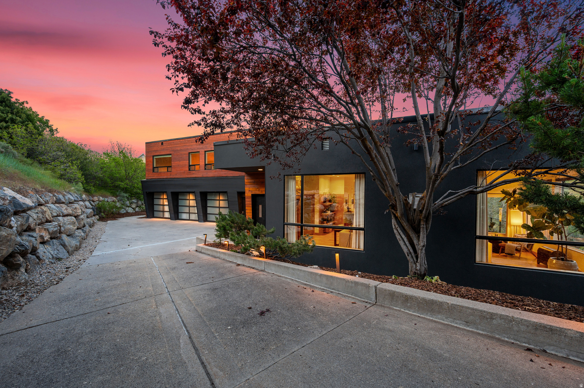 This incredible property in Emigration Canyon offers something extremely rare: the seclusion and stillness of canyon living, with the city only minutes away. At just over 5,400 square feet, the scale is generous while still feeling intimate. Four bedrooms, six baths, and a large loft provide plenty of space for entertaining in style. The living, dining, and kitchen areas flow openly into one another, anchored beautifully by massive south-facing windows that flood the space with natural light and frame unobstructed canyon views. Wood floors soften the modern edges throughout, keeping the interior warm rather than austere. Every room is thoughtfully positioned to capture both light and landscape. The living room looks out at an exterior deck and the surrounding land, and a modern and sleek kitchen takes full advantage of panoramic windows overlooking the scrub oak hillside. There are all the high-end finishes you would expect, plus a couple you might not (like heated radiant floors throughout, solar power, and a beautifully situated hot tub).  Three decks off the home (one on each level) extend the living space outward, each oriented toward the lush and unobstructed terrain to the south. A fourth patio provides a dedicated space for lounging and outdoor dining under the string lights and stars. A favorite feature here is the private trail network, accessible directly from the back yard, which winds in a few directions through the trees and offers immediate access to nature's best without needing a car. A roomy three-car garage rounds things out, providing space for vehicles, gear, and projects alike. This home places you squarely inside the landscape without asking you to sacrifice anything. Properties of this caliber, in a setting this rare, do not come available often.