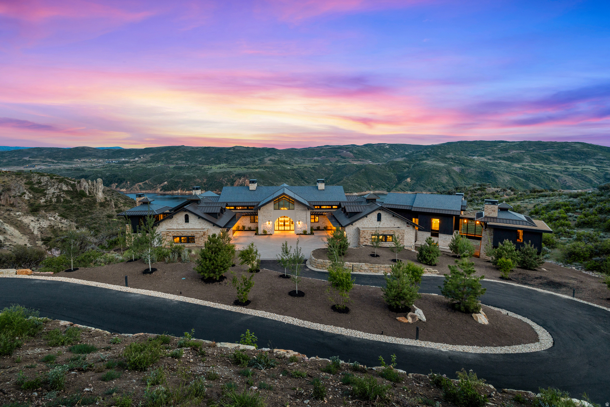 Dubbed the Water-Earth-Sky Villa by the renowned architectural team at Berg Design-8988 Sleeping Rock is a private sanctuary where modern luxury meets nature's grandeur. Designed for those who value privacy, peace, and timeless elegance, this custom-built residence sits high on the cliffs on one of the premiere lots in the Lone Peak neighborhood of Tuhaye. Situated on 5.97 acres, the stunning home offers breathtaking uninterrupted views of Jordanelle Reservoir, Mount Timpanogos, Deer Valley and the Wasatch Back. Every detail of this home has been meticulously crafted in order to create the ideal indoor and outdoor living environment. The open-concept living space flows effortlessly onto an expansive terrace and infinity edge swimming pool-perfect for entertaining or simply soaking in the views. Whether it's sunrise over the water or golden-hour light and sunset across the peaks, every moment here feels cinematic. Spanning 11,847 total square feet, the separate wings of the home are connected by breezeways allowing for a private, yet inclusive, aesthetic for owners and guests. The main floor of the home boasts a large great room and kitchen with walls of glass, a 2-way fireplace, butler pantry, a primary bedroom wing, 2 dens, a guest suite and duel mudrooms. The basement level features 3 additional guest suites, an en-suite bunk room, a large entertaining space with a 2-way fireplace and bar, a recreation room, fitness room and walk-out access to large outdoor spaces. Included with the purchase is the $200K membership deposit to the Talisker Club, which features the Mark O'Meara championship golf course, Village at Tuhaye, recently completed Basecamp, 2 pools, Spa, Fitness Center, tennis/pickleball courts, soon-to-be completed Par-3 course, Moondance Park, hiking and biking trails; the Tower Club in Empire Pass at Deer Valley Resort; the Courchevel Bistro on Main Street; and The Outpost- your own backcountry playground.