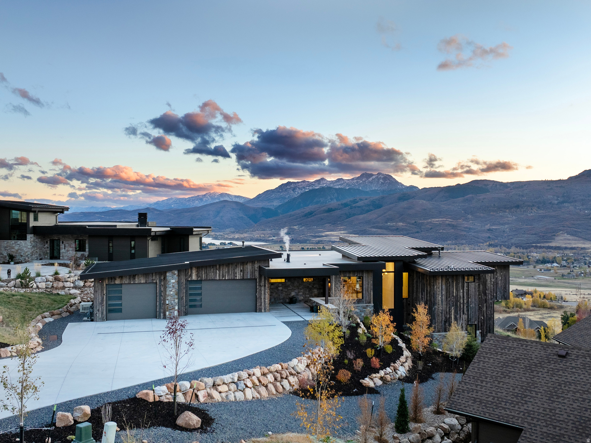 Experience the pinnacle of Ogden Valley luxury living in this stunning Mountain Modern estate nestled in the prestigious Highlands at Wolf Creek in Eden, Utah. Masterfully designed by Bertoldi Architects and crafted by Big Canyon Homes, this one-of-a-kind property seamlessly blends architectural elegance with curated, high-end custom interiors. Wake up to unobstructed panoramic views of the Wasatch Mountains, Snowbasin Ski Resort, and Pineview Reservoir from nearly every room. Thoughtfully designed for indoor-outdoor living, the open-concept main level showcases a chef's kitchen equipped with a Wolf range, double ovens, double sinks, and a spacious walk-in pantry - ideal for entertaining at altitude. A generous laundry room with custom built-ins adds everyday functionality to the luxury experience. The Great Room anchors the home with a dramatic floor-to-ceiling stone fireplace and trifold doors opening to a wraparound deck with firepit - the perfect setting for watching alpenglow settle over the Wasatch Mountains. The primary suite is a true retreat, featuring its own fireplace, private deck, spa-inspired bathroom, and an expansive dressing room. Every bedroom is ensuite, offering privacy and comfort for family and guests alike, complemented by two additional powder rooms. The lower level impresses with tall ceilings, a covered patio with Bullfrog spa, a glass-enclosed office and library, a wet bar with dedicated wine area, and a private fitness room. Smart home features include a whole-home Sonos audio system, automated window shades, and a breathtaking Murano chandelier. Outside, enjoy low-maintenance landscaping, gas hookups, a heated oversized driveway, and a 3-car garage with ample storage. Unbeatable location, minutes from Powder Mountain, Nordic Valley Ski Resort, Wolf Creek Golf Course, Pineview Reservoir, and world-class Ogden Valley trail systems for hiking, biking, and Nordic skiing.