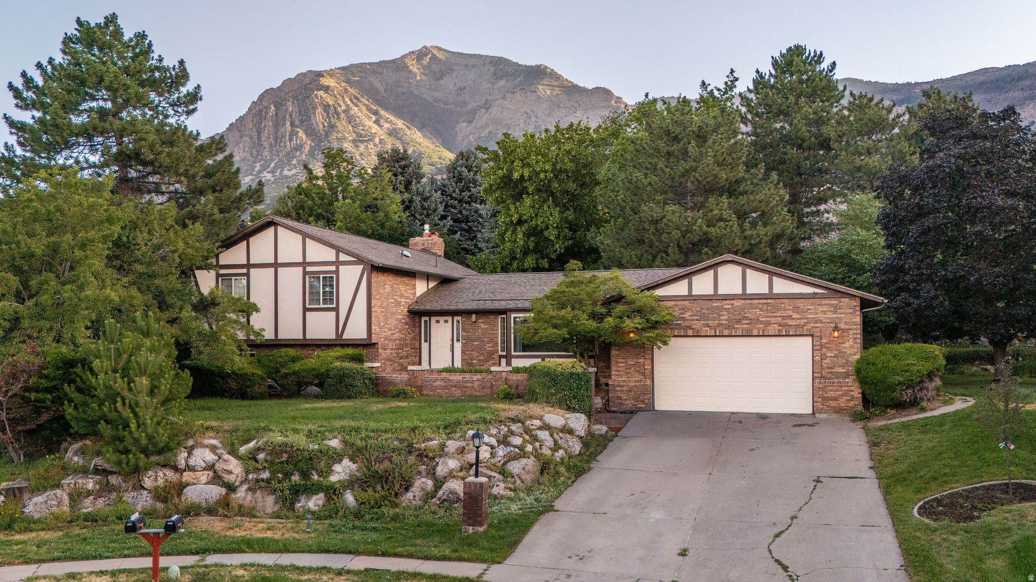 This beautifully updated North Ogden home features an impressively large kitchen with a large central island, a JennAir gas cooktop, deep oak cabinets for abundant storage, and a built-in desk area. Enjoy a large family room with a cozy fireplace that walks out to a phenomenal, private backyard shaded by mature trees with access to expansive park space. The master bedroom offers its own private walk-out deck overlooking the grounds. Major mechanical items offer complete peace of mind, featuring a recently replaced roof and a new tankless water heater. In a market where buyers have options this five bedroom home in a cul-de-sac is priced to sell.