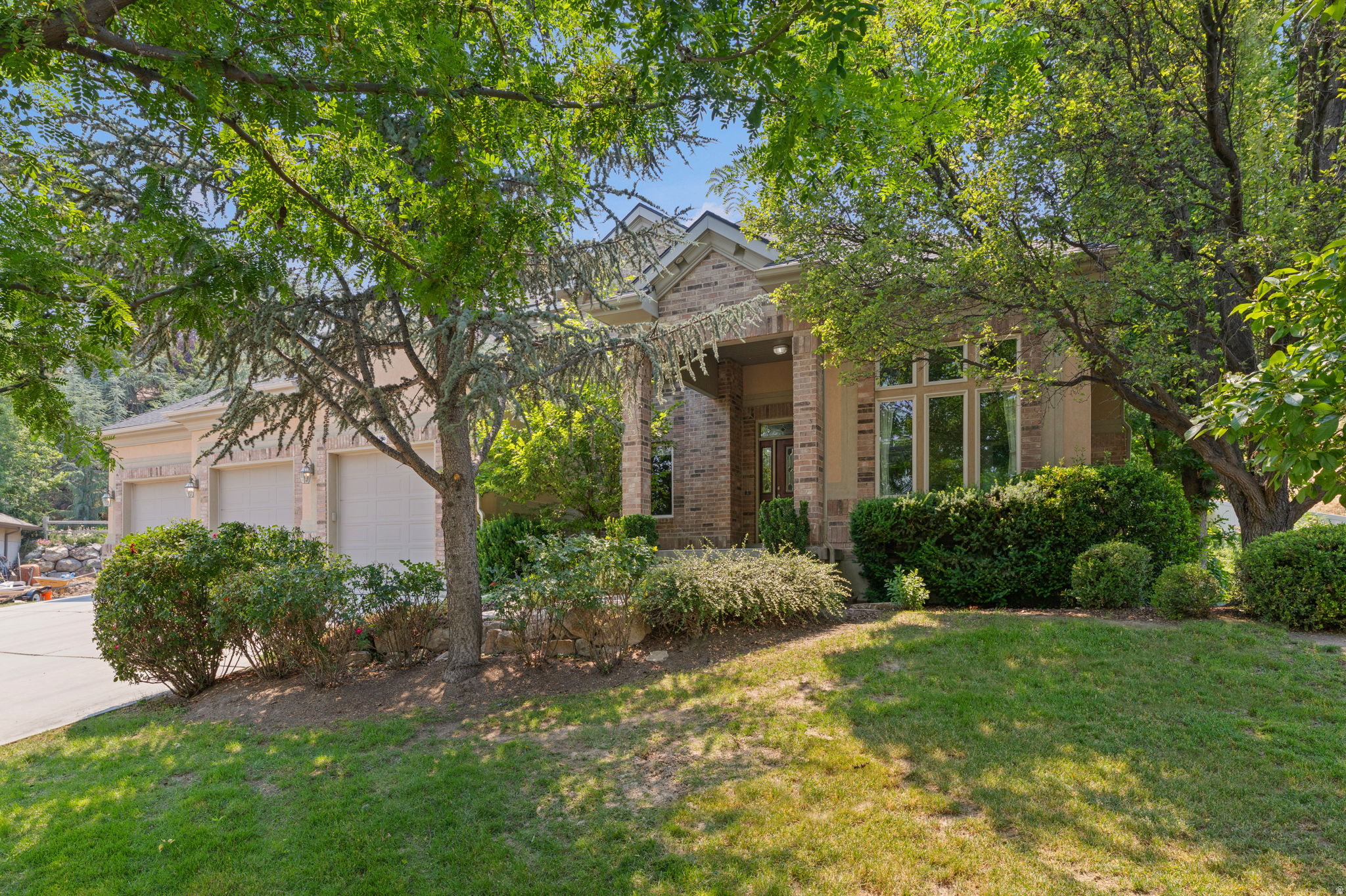 Welcome to this stunning, expansive residence tucked away on a quiet cul-de-sac in one of South Jordan's most sought-after neighborhoods. Perfectly positionedagainst a serene hillside, the property offers exceptional natural privacy amid lush, mature landscaping. Featured in the Parade of Homes when built, this impressive property showcases timeless design, quality craftsmanship, and spacious living throughout.  The main level features an open-concept kitchen, dining area, and family room with a gas fireplace and walks out to a spacious deck. The kitchen offers custom cabinetry, Silestone countertops, a large island, Wolf double ovens, and a gas cooktop. The main level also includes a living room and flex room, creating additional living and entertaining space.  Upstairs, the primary suite includes a gas fireplace, walk-in closet, private covered deck, and ensuite bathroom with two vanities, jetted tub, and separate shower. Two additional bedrooms share a Jack-and-Jill bathroom, and an office with soaring ceilings, large windows, built-in custom cabinetry and desk. Upstairs laundry adds convenience.  The lower level includes a spacious family room with a full second kitchen, two bedrooms, a full bathroom, and a large unfinished room with extra ceiling height. This area is ideal for guests or mother-in-law living. Also includes a large storage room.  The backyard offers exceptional privacy with no direct rear neighbors, expansive deck space, and an in-ground hot tub surrounded by a beautiful hillside backdrop. Additional outdoor features include an in-ground trampoline, covered outdoor dining area with built-in heater, swingset, and multiple spaces for entertaining and relaxing.  Rare 5-car garage with exceptional space for vehicles, recreational gear, storage, or a workshop. Additional highlights include solar panels, exterior security cameras, and Ring doorbell system.  Conveniently located near shopping, dining, parks, schools, and freeway access.