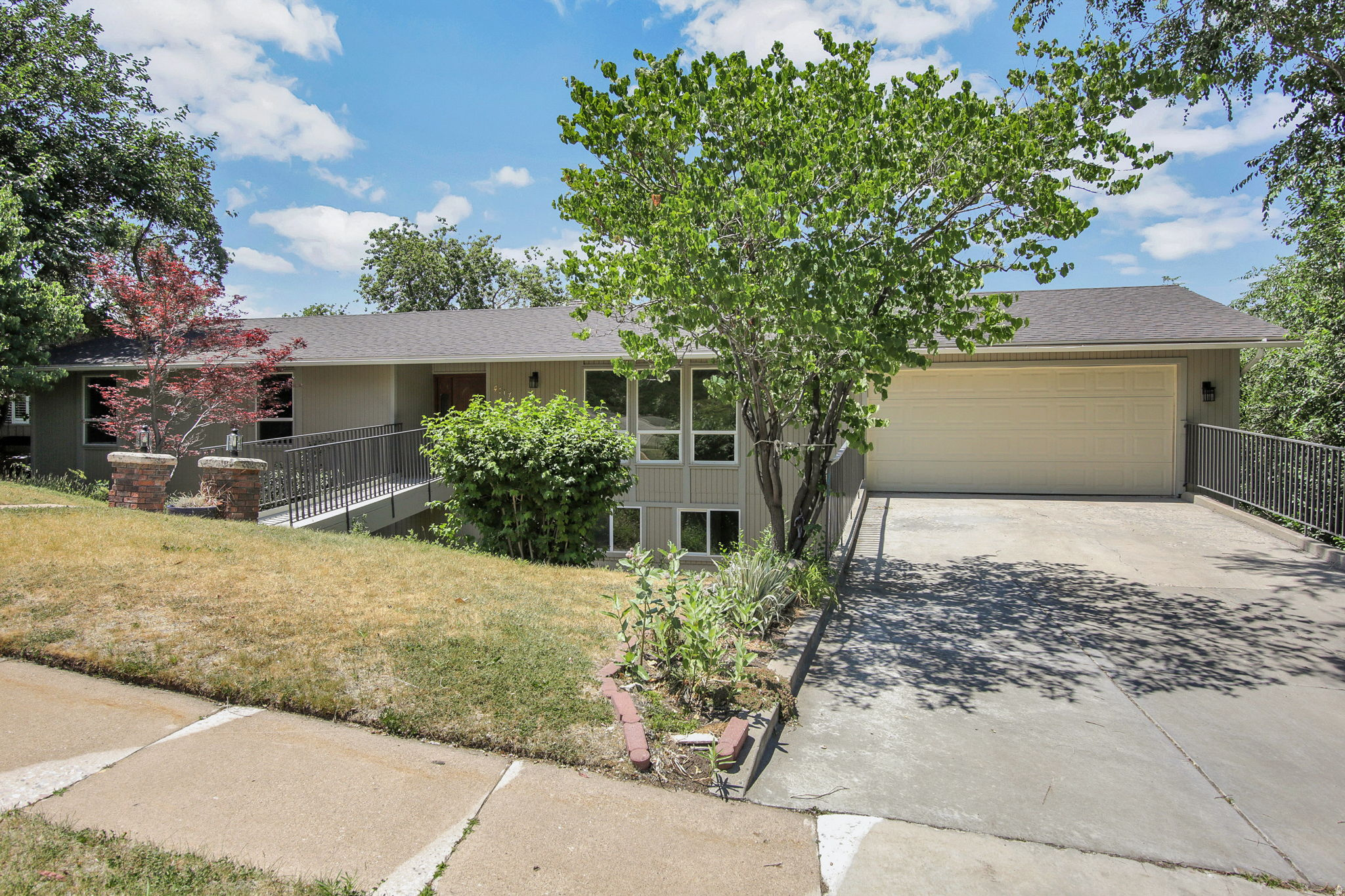 Fantastic high east bench location above Weber State. Lovely cedar rambler with mountain views to the east and three levels of valley views to west. Seller is motivated and home has been priced well for some kitchen, and tile floor updates. Great for multi-generational living or space for extra income. Home has just been freshly painted and new carpet throughout! Not a cookie cutter layout with formal dining room, bayed windows on all levels, wood beams in kitchen and large fireplace in great room. 5 Spacious bedrooms and four baths.  Home boasts two of those as primary bdrms, on main and lower level. 480 feet of the lower level is a separate space used as a sports court. This home has real potential for bringing your creative ideas into a higher level of living while maximizing its value.