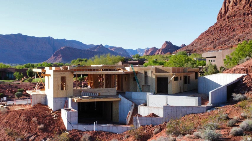 Experience elevated desert living in this remarkable custom home by Shakespeare Development, offering over 7,000 square feet of luxury and design excellence. Perfectly positioned to capture the breathtaking red rock views, this residence seamlessly blends modern architecture with the natural beauty of its Entrada surroundings. Designed for both comfort and entertaining, the home features two expansive levels, two family rooms, a private gym, and an inviting office. The gourmet kitchen and open-concept living spaces flow effortlessly to the incredible outdoor living area, where a resort-style pool and multiple lounging spaces create the ultimate retreat. With 4 spacious bedrooms, 6 luxurious bathrooms, and an oversized 5.5-car garage, every detail has been thoughtfully crafted for an unparalleled lifestyle of sophistication and comfort.