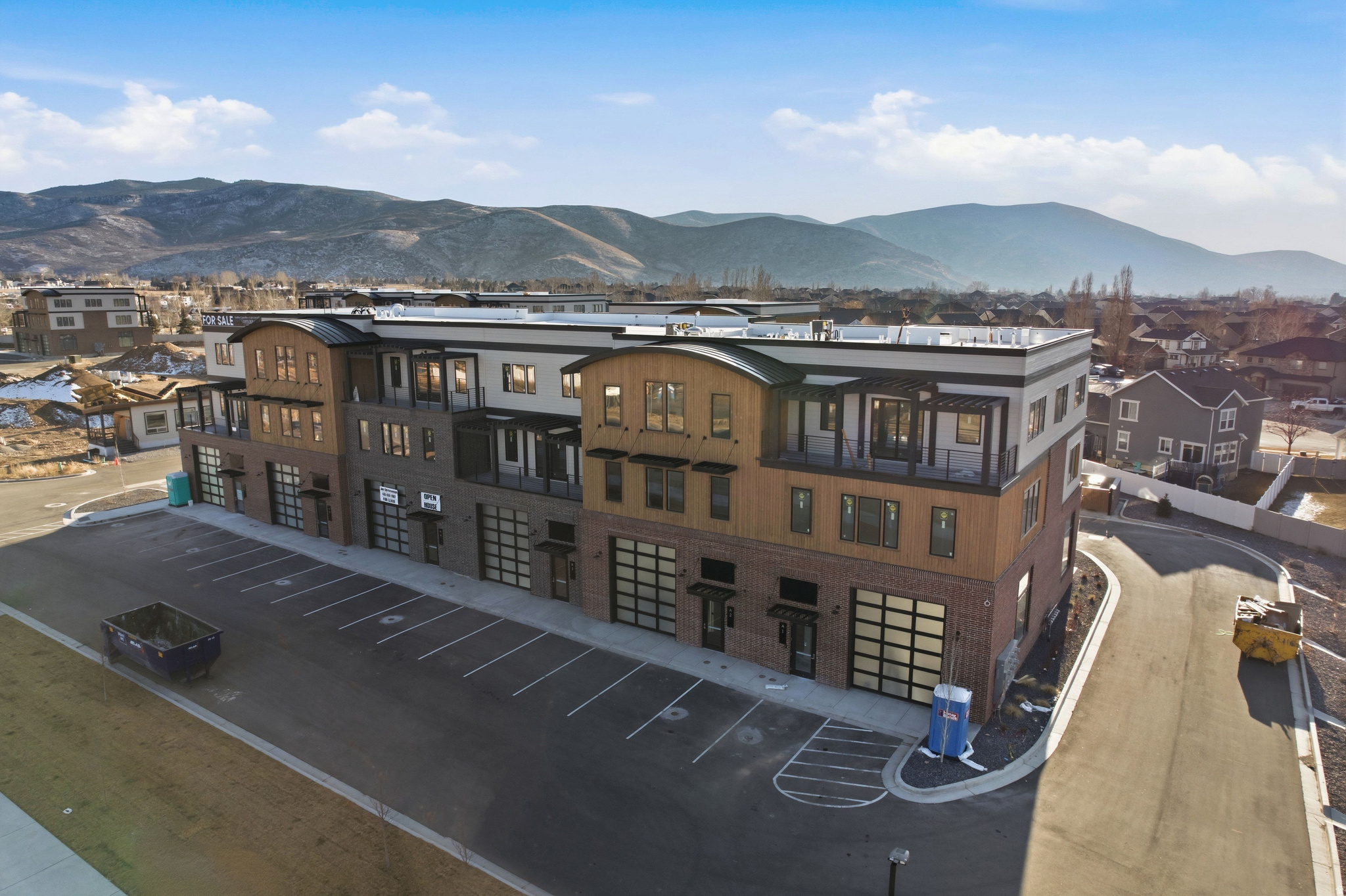 Unit 2 at Mountain View Commons showcases the highly sought-after Outlaw floor plan, offering a rare opportunity to blend commercial and residential living within one property. Mountain View Commons is a premier mixed-use development allowing 40+ permitted residential and commercial uses, creating flexibility for owner-users, entrepreneurs, and investors alike. This three-level layout offers approximately 5,400 square feet total, with roughly 1,800 square feet per level, designed to adapt to a wide range of lifestyle and business needs. The main (lower) level features a 30' x 60' warehouse-style flex space with 16+ foot clear heights and two oversized 14' glass garage doors, providing pull-through access. This level is ideal for commercial, storage, or hobby use, and also serves as a versatile environment for entertainment, gatherings, private retreats, or creative studio space. With its scale, access, and separation from the residential levels above, it offers an ideal setup for hosting out-of-town guests or accommodating visiting employees. Elevator and stair access connect all three levels. The second level is designed for residential living and features a beautifully appointed kitchen with a premium Fisher & Paykel appliance package, custom cabinetry, and high-end finishes that reflect thoughtful craftsmanship. This level also includes an office, a large laundry room, and a spacious family room framed by views of Heber Valley and Mount Timpanogos-perfect for everyday living and entertaining. The third level completes the experience with 360-degree views of Heber Valley and offers three full-size luxury bedrooms, a well-appointed bathroom, and oversized custom closets for each bedroom, creating a private retreat. Whether you're seeking a live/work environment, on-site business headquarters, or a mixed-use investment, The Outlaw at Mountain View Commons delivers exceptional design, flexibility, and mountain views!