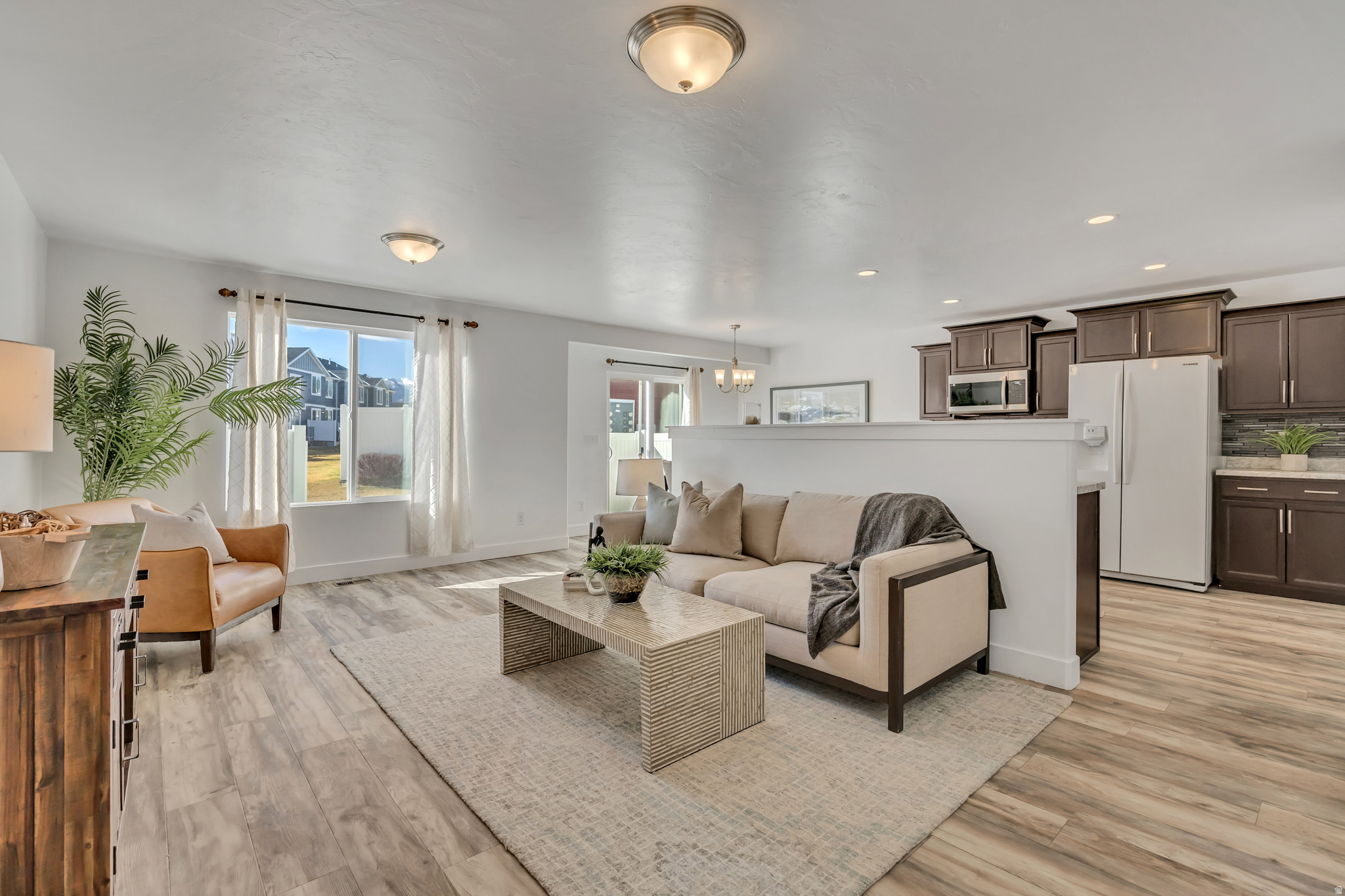 OPEN HOUSE SATURDAY, 6/27/26 from Noon to 2:00 pm!! HUGE PRICE IMPROVEMENT! $192 sq ft (with finished basement). Beautiful townhome with fresh updates! New carpet/pad, new paint in most rooms. The main floor boasts an open-concept with stylish cabinetry, spacious kitchen with storage, new oven &  new microwave & laminate flooring. Includes refrigerator, washer & dryer. Garage floor has been newly painted & flecked. Backyard is fully fenced & has open green space behind. Layout includes 4 bedrooms, 3 full bathrooms. The seller family used basement room as a bedroom with no closet but could also be used as a family room. Basement is fully finished & includes a kitchenette w/a sink, microwave space, small refrigerator & cabinets. Close to shopping,  Mtn Corridor, Herriman Rec Center & Library. Buyer/buyers agent to verify all.