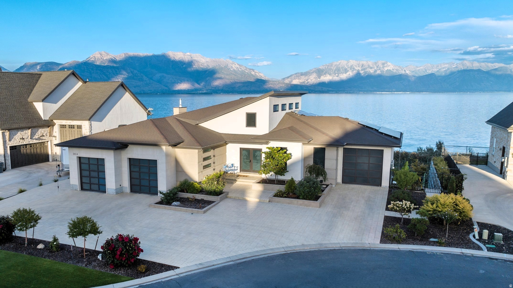 Custom-built waterfront luxury resort home, located within a private lakeside community, featuring breathtaking panoramic views of Utah Lake and the Wasatch Mountains. The unique and spacious design with large windows and vaulted ceilings provides a light and open atmosphere. Extensive features and high-quality construction make this meticulously cared for home truly exceptional.   Be captivated with beautiful landscaping, thoughtfully designed interior, extensive features, and the serene backyard with lake and mountain views! Adding to the resort feel, is an indoor spa (with independent heating, cooling and ventilation systems) featuring a hot tub, private bathroom and a steam sauna. The gourmet kitchen features Wolf double wall ovens. A Wolf gas cooktop, with a retractable vent is built into the sea foam and white quartzite island. A butler's pantry is stationed behind a privacy door with its own sink, countertop and shelves for appliances, keeping the kitchen uncluttered. This Smart Home is highly automated for convenience. Controlling the automation is a server rack, with fiber optics, supplying a whole home network, security cameras, sensors, electric key locks, and interior/exterior lighting automation. A 10kv solar power system, with DC inverters and a separate sub-panel, provides abundant energy savings. A hybrid water heater providing continuous hot water, whole-home water filtration and a multi-zone high efficiency HVAC system provides ultimate comfort.  Enjoy main-level living with ADA accessibility, including wheelchair accessible shower, wide doorways, raised outlets, automated faucets and a spacious, built-in elevator to transport you and your things between levels.  The walkout basement is configured with a full kitchen, 3 bedrooms, 2 bathrooms, laundry/bonus room, family room and a separate entrance. The design allows for slight modifications to make this an entirely independent living space.  This premium waterfront lot is fully landscaped with raised beds and enclosed with a steel, powder-coated fenced, creating a secure haven with exotic plants, shrubs and trees, only requiring minimal water usage and maintenance with automated drip-line watering.  Spend quiet, tranquil alone time admiring wildlife on your full-length covered deck and patio or host large gatherings, enjoying the ambience of background music played through integrated indoor and outdoor speakers with individual controls. The abundant primary garage is finished with epoxy floors, an electric vehicle charging station, a gas line for a future heater and a spacious, lockable, storage closet. The bonus garage is perfect for a vehicle, boat or workshop.  This solidly built home includes enhanced engineering and additional features detailed in the Home Features Summary attachment on the MLS. When venturing beyond your personal retreat, enjoy the unique and extensive amenities within Saratoga Springs' private resort community and adjacent golf course. Amenities include a one-of-a-kind year-round natural hot-springs pool and spas, private boat marina, parks, trails, and multiple lakefront clubhouses with games rooms, exercise facilities, etc. All information is provided as a courtesy and deemed reliable but not guaranteed. Buyers are responsible for verifying all information. To view a video and a point/click 3D property tour click "View Tours" below the pictures on the MLS, or visit: https://player.vimeo.com/video/1191221337?byline=0&title=0&owner=0&name=0&logos=0&profile=0&profilepicture=0&vimeologo=0&portrait=0  (for video) or https://my.matterport.com/show/?m=sDBWR3fZGV1  (for 3D tour).