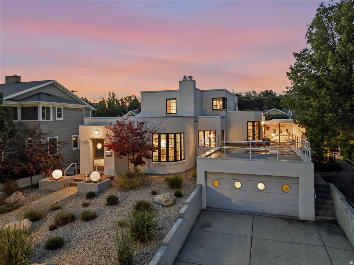 With an unmistakable silhouette, this Art Moderne residence cuts through the neighborhood like a luxury cruiseliner: white stucco, curvilinear walls, a flat roof, and just enough nautical flair. The unique design doesn't stop at the threshold. Original details like diagonally laid wood floors, masterful tilework, and authentic 1930s light fixtures fill each space. Each owner over the past century has cherished the high-quality craftsmanship and carefully chosen updates that are consistent with the home's character. The kitchen boasts finely crafted, curved mahogany cabinetry and a dining nook complete with an authentic Art Deco table-perfect for your morning beverage. A formal dining room is available for gatherings, and when you'd like to entertain outside, you have options: a well-equipped covered patio with a fireplace, Murphy bed, and hot tub; a sunny deck with a bird's-eye view; or a private side yard sitting area. The entire top level is dedicated to the primary suite, featuring a freshly remodeled luxury ensuite, a full dressing room, and a peaceful sitting area, which opens to your upper-level terrace. Sustainable upgrades like a smart thermostat, water-wise landscaping, and solar panels are seamlessly integrated into the design. Factor in an attached garage, custom built-ins, gallery lighting for your collections, and updated Pella 850 wood windows and doors, and you've got all the modern amenities you need wrapped in unmatched retro style. Located just a stone's throw from the University of Utah, the home is close to downtown and the mountains. Walk along tree-lined streets to neighborhood parks, a beloved public library, and top-rated schools. Finding an intact Art Moderne gem is rare enough-but in the Yalecrest neighborhood, it's an absolute one-of-a-kind.