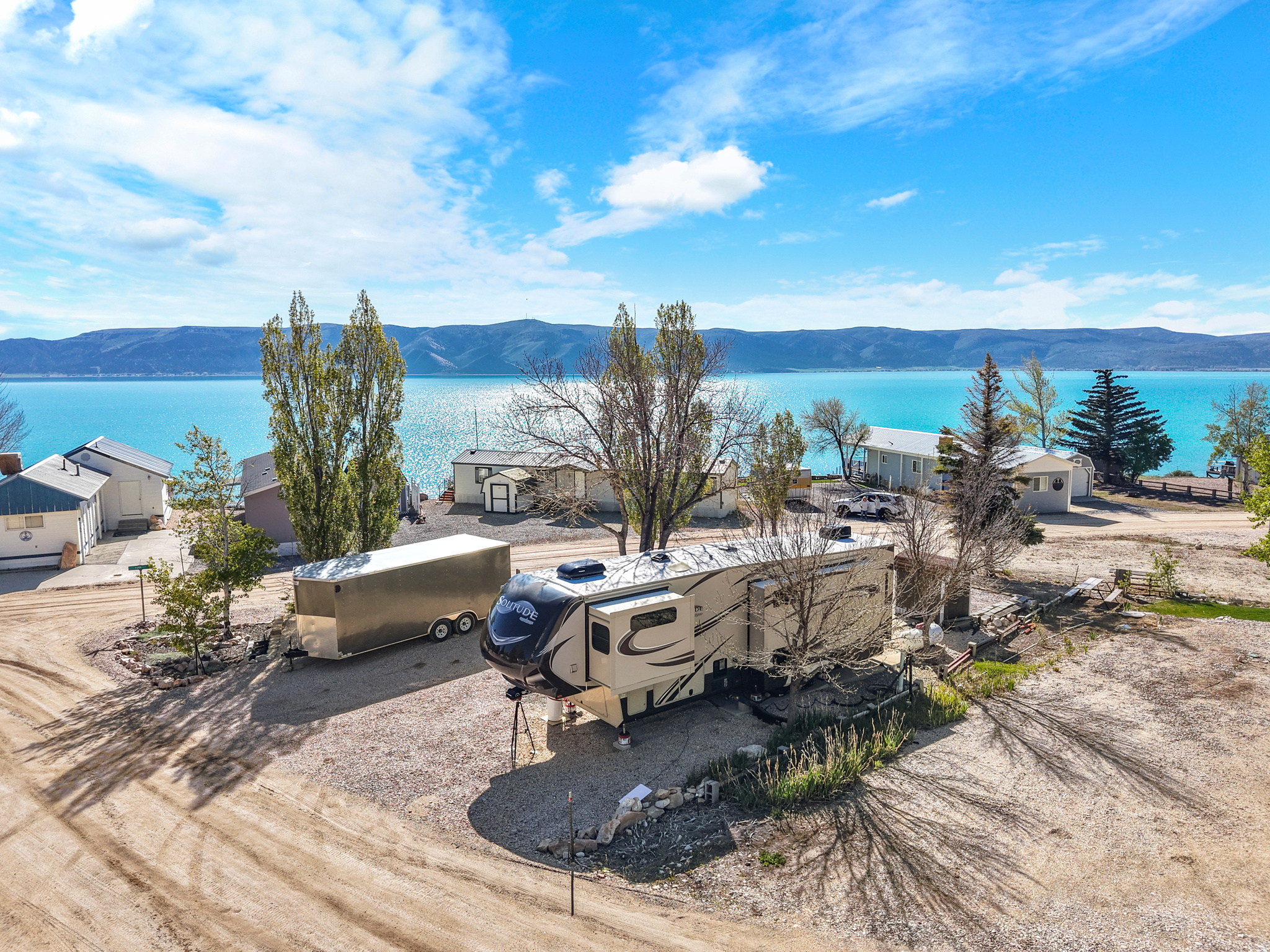 Spacious corner lot in Sweetwater Ridge with view of the lake. Not many lots come up in this park, this is one of the best.  Lot has 4 sewer hookups and 2 power hookups.   Bring your trailer(s) or place a mobile home on this one.  Shade trees, concrete patio, small shed, graveled flat lot.  Community pool, 2 playgrounds, large common areas make this location one of the jewels at the lake for family fun all summer long!  HOA provides temporary parking for guest's trailer parking (with reservations) and has activities throughout the summer for the members. 5' x 6' shed and 100 gallon propane tank included