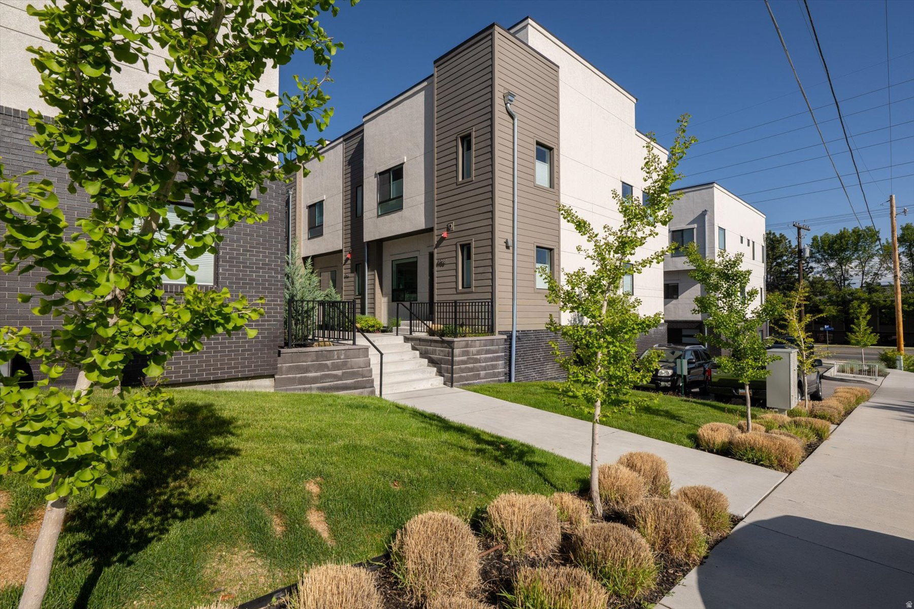 Welcome to this upgraded corner-unit townhome in the Union Lofts community, ideally located near the entrance to Big and Little Cottonwood Canyons with convenient access to shopping, dining, skiing, I-215, and downtown Salt Lake City. Built in 2021, this 4-bedroom, 3.5-bath residence offers approximately 1,941 square feet of living space, a 2-car attached garage, and a rooftop deck with mountain views. The home features an open-concept main level with hardwood flooring, natural stone countertops, Samsung kitchen appliances, a reverse osmosis water filtration system, and an electric fireplace. The basement includes a private guest suite with a full bathroom, while the second floor offers a primary suite and two additional bedrooms currently utilized as an office and gym. Additional owner improvements include expanded rooftop decking, luxury vinyl flooring on upper levels, custom in-wall Sonance speaker system, built-in garage storage, custom window coverings, and upgraded bathroom lighting. Community HOA dues are approximately $225 per month and include water, sewer, trash, snow removal, grounds maintenance, and earthquake insurance Certain furnishings and garage cabinetry may be available for separate purchase outside of the real estate transaction.