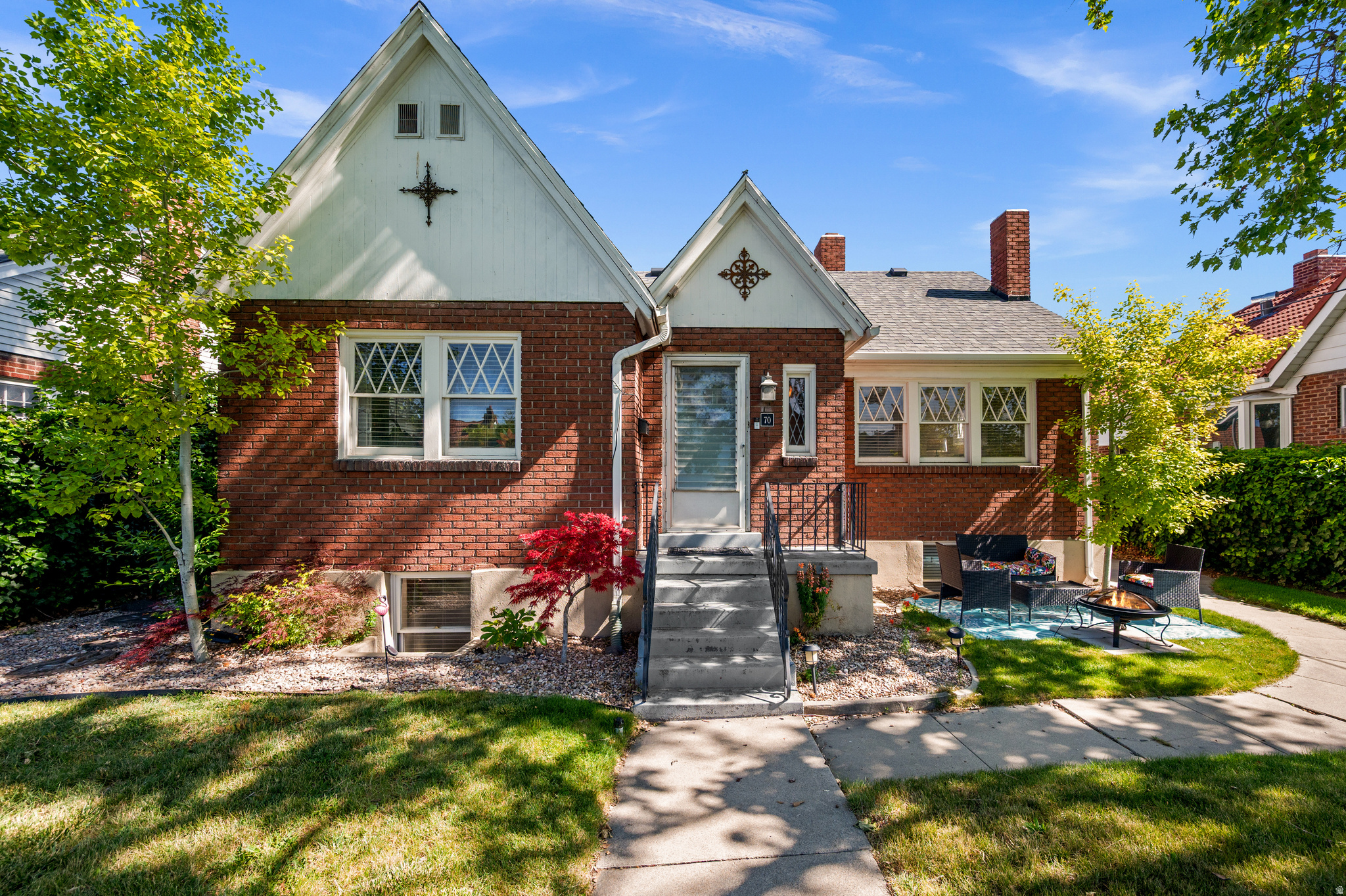 A unique and beloved Salt Lake City neighborhood, Boulevard Gardens is listed on the National Register of Historic Places. This distinctive and tucked-away 1929 subdivision consists of twenty-three brick Tudor cottage-style homes arranged around a shared garden courtyard, and the sense of community here is palpable. Each residence faces a common greenspace measuring roughly 80 feet wide and 800 feet long, creating one of our city's most well-preserved garden suburb enclaves. The home itself has plenty of details that lend timeless character, such as arched doorways, a cozy fireplace, stained glass windows, original light fixtures, and hardwood flooring throughout. A thoughtfully updated kitchen blends historic charm with modern functionality, thanks to some exposed brick, a large farmhouse sink, butcher block countertops, and the kind of natural light that feels intentional and inviting. Four generously sized bedrooms with ample natural light provide flexible space for guests, family, or home office use, and a separate basement entrance offers some great potential for a future mother-in-law apartment with the addition of a kitchenette. A detached garage offers a cool spot for cars or storage, and it's recently been updated with finished drywall and fresh paint. Beyond the signature shared garden courtyard, the private backyard is a highlight of the property-thoughtfully designed for outdoor living, lucky residents here can enjoy a large pergola, adjustable shade sails, and plenty of space to relax, entertain, or enjoy warm summer evenings in a peaceful setting. Home in this special pocket of our city don't often hit the market, so this is your moment.