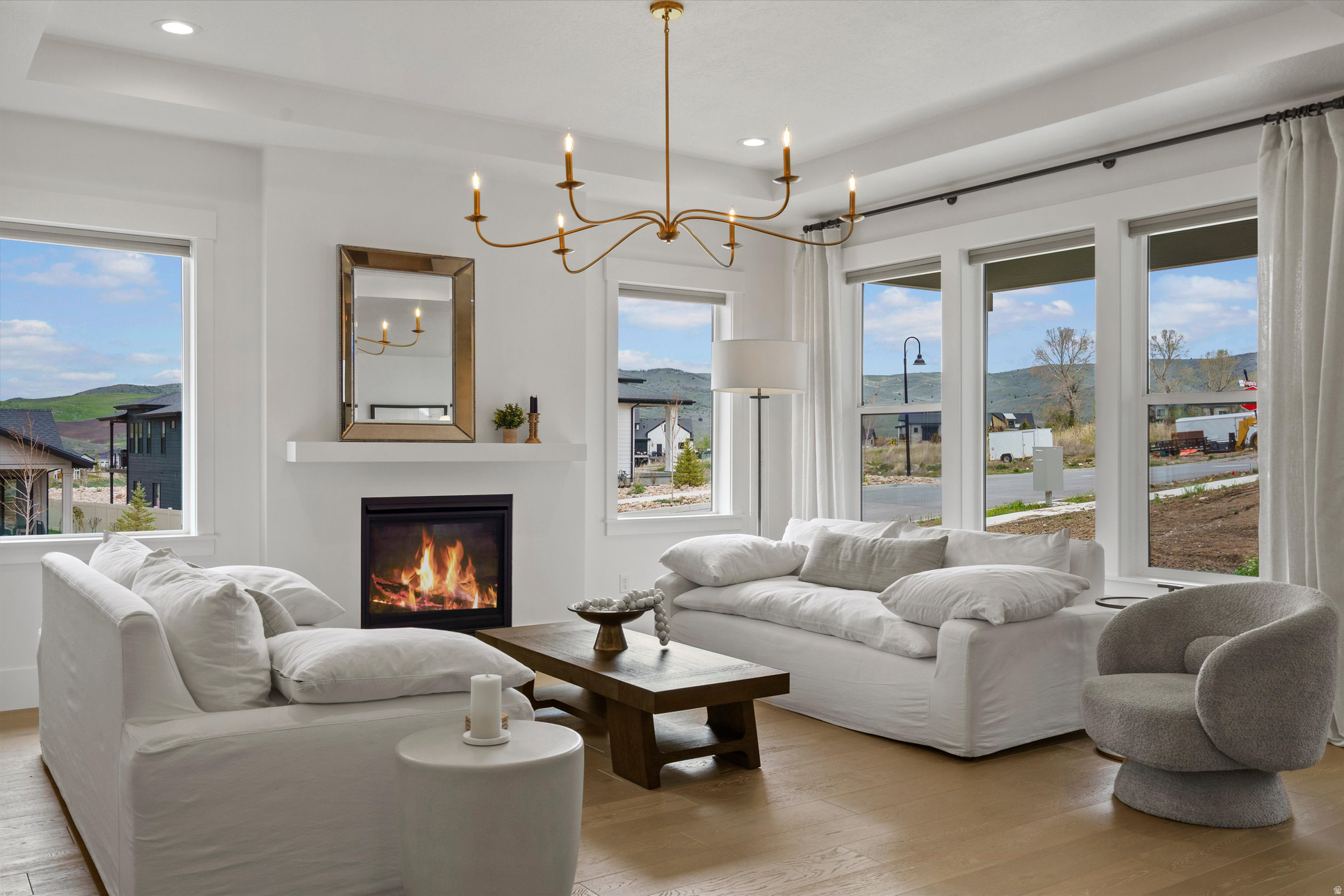 Located in The Cottonwoods, one of Mountain Green's most sought-after communities, this nearly new residence offers a refined balance of elevated design and low-maintenance living. With just one year of light use, the home presents in exceptional, like-new condition. Positioned on a desirable corner lot, it is filled with natural light and finished in a cohesive, designer-curated palette that carries seamlessly throughout. The main level is anchored by Mohawk engineered hardwood flooring and a thoughtfully designed kitchen with a large island, quartz countertops, GE Caf appliances, and elevated designer lighting-equally suited for everyday living and effortless entertaining. The fully finished basement extends the home's livability with a spacious great room, 100% wool Karastan carpeting, and three additional bedrooms, including a private en suite. Just outside your front door, enjoy access to miles of community trails and nearby parks, with world-class skiing at Snowbasin Resort only a short drive away.  This spring the developer will be finishing the professionally maintained landscaping which enhances the home's clean, lock-and-leave lifestyle-offering a rare combination of comfort, quality, and understated luxury in one of the area's most desirable settings.