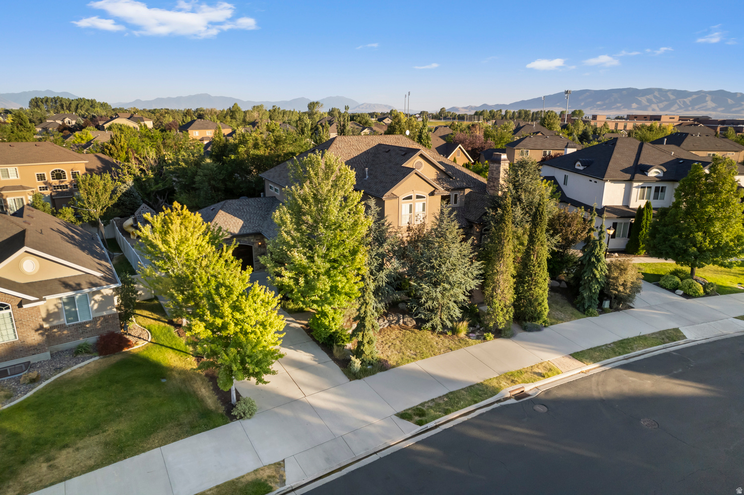 Welcome to 292 E Clubview Lane - a nearly 6,000 square foot masterpiece tucked into one of Lehi's most sought-after neighborhoods. From the moment you step inside, you'll notice the elevated finishes that set this home apart. Rich, custom cabinetry flows throughout, showcasing expert craftsmanship and timeless design. The expansive, open and extra-wide floor plan makes entertaining and daily living effortless. The chef's kitchen, spacious living areas, and dreamy laundry room (with hookups for two sets of washers and dryers) combine function with luxury. The owner's suite is a true retreat, featuring a spa-caliber bathroom with triple shower heads, a separate soaker tub, and one of the most jaw-dropping walk-in closets you'll ever see. Fully built out with extensive cabinetry, built-in organizers, and even a center island, this closet feels more like a boutique dressing room. Downstairs, the deluxe theater room is ready for movie nights or weekend marathons in style. Outside, your private resort awaits: a lush, secluded backyard oasis with a peaceful river, waterfalls, hot tub, and an outdoor kitchen-perfect for summer BBQs and quiet evenings. An RV pad offers extra space for your toys and adventures, while the garage comes wired for your electric vehicle. Enjoy the comfort of instantaneous hot water throughout the entire home, making every shower and bath an indulgent experience. Living here means exclusive access to Ivory Ridge's world-class amenities, including a tennis club (indoor and outdoor courts), pickleball courts, swimming pool, and weight room-all just minutes away. You'll also love the convenient proximity to Skyridge High School, ensuring you're close to schools, shopping, and the best of Lehi living. A rare blend of size, style, and setting - this home truly delivers on every front. Square footage figures are provided as a courtesy estimate only and were obtained from previous MLS listings. Buyer is advised to obtain an independent measurement.