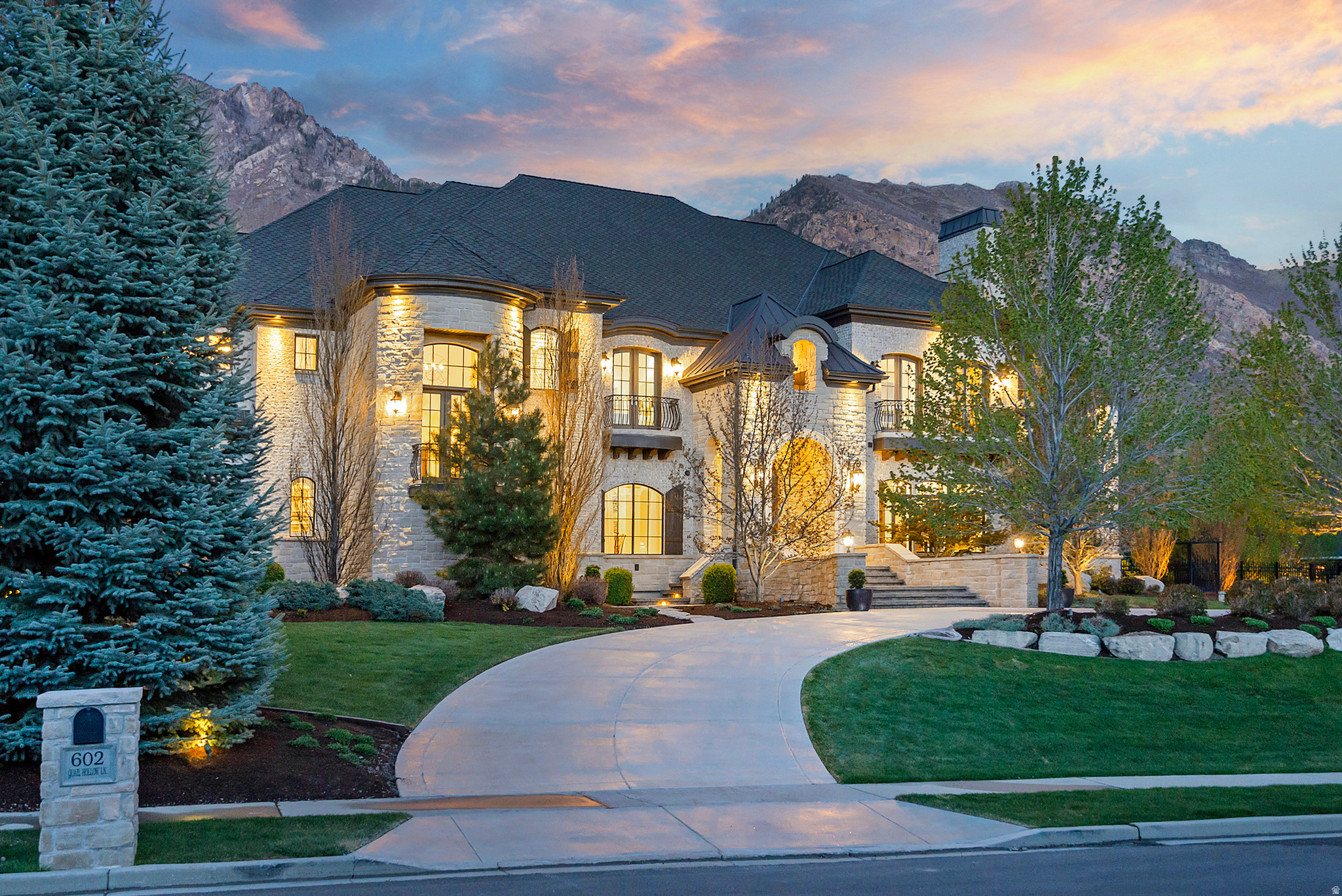Set on lush, private grounds in one of Alpine's most coveted enclaves, this 17,297 square-foot estate is a masterwork of craftsmanship and scale. Floor-to-ceiling windows greet you at entry, framing sweeping mountain views across the main living space. The gourmet kitchen features an oversized pantry, and dedicated his-and-her offices provide space to work without compromise. Six generously scaled bedrooms and eight bathrooms serve the home, anchored by a 1,200+ square-foot primary suite designed as a true retreat. The primary bath features a steam shower, large jetted soaking tub, integrated television, heated floors, and in-suite laundry hookups. Abundant storage is woven throughout the home. Many convenient home automation features grace the home. A full fitness level includes a weight room, private massage room, sauna, and a multi-purpose regulation court with hardwood floors featuring three basketball hoops, pickleball and volleyball configurations, and an automated projection system that transforms the space from gym to professional presentation or cinema venue at the touch of a button. Multiple entertaining spaces flow throughout the main levels, while the walkout daylight basement adds a private theater, second full kitchen, and direct access to an outdoor living area with hot tub, built-in BBQ, and fire pit. Outside, twin pergolas and a water feature accent the side patio, while a separate back patio offers a fire table and splash pad. An oversized four-car garage with radiant-heated driveway completes the property.