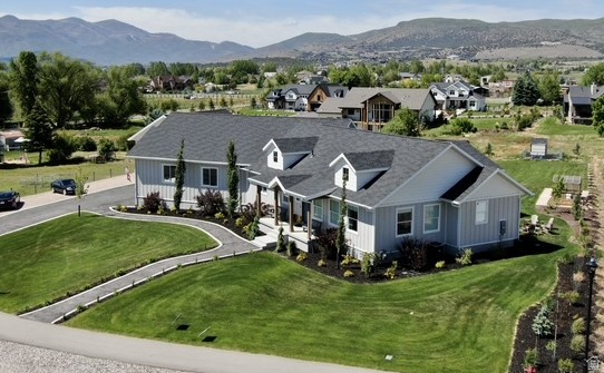 Nestled on the highly sought-after east side of Heber Valley, this stunning 4,200 sq ft rambler offers the perfect blend of space, functionality, and breathtaking views. Designed with an expansive open floor plan, the main living area features a beautiful brick fireplace and seamlessly connects the oversized living room, gourmet kitchen, and semi-formal dining space-creating the ultimate gathering hub. The kitchen boasts a massive island, large pantry, and effortless flow to the covered, heated back deck, ideal for year-round entertaining while overlooking the private one-acre lot. The main-level primary suite provides convenience and comfort with a beautifully appointed ensuite bathroom. Downstairs, you'll find four generously sized bedrooms with walk-in closets, a spacious family room, wet bar, second laundry, and ample storage. Car enthusiasts and hobbyists will love the massive attached garage, complemented by an additional detached two-car garage with a studio ADU above-perfect for guests or generating rental income. The property also includes a backyard shed, chicken coop, and a large gravel pad with plenty of room for RVs, boats, and all your toys. Enjoy privacy, elbow room, and unobstructed panoramic views of the valley and Mount Timpanogos in this peaceful, rural-feeling neighborhood. This property truly has it all-space, versatility, and lifestyle. Square footage figures are provided as a courtesy estimate only and were obtained from tax data. Buyer is advised to obtain an independent measurement.