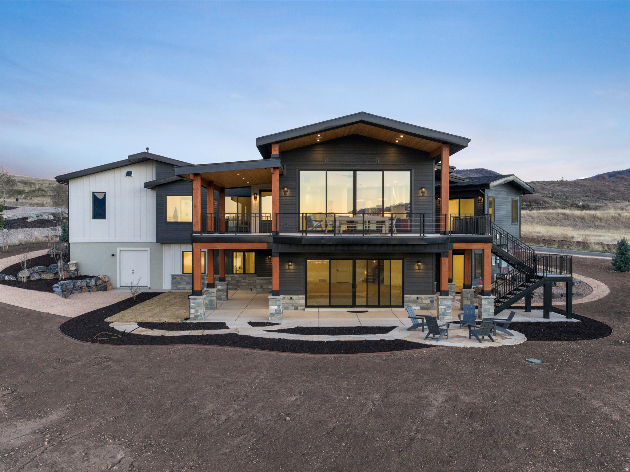 Perched above Ogden Valley in the exclusive Trappers Crossing development, this luxurious 4,820 sq ft mountain residence offers unobstructed views of Snowbasin Ski Resort and Pineview Reservoir, elevated further by Snowbasin's selection as a 2034 Winter Olympic venue. Brand new construction, this custom build is designed with a seamless blend of refined mountain architecture and modern performance. Five bedrooms, six bathrooms, vaulted ceilings, expansive windows, and an open-concept great room to frame the views while creating an ideal setting for everyday living and entertaining. The chef's kitchen features top-tier SKS appliances, dual-fuel gas/electric range, dual dishwashers, Taj Mahal stone surfaces, and direct deck access for outdoor grilling and indoor-outdoor dining. The primary suite is a private retreat with deck access, radiant-heated floors, steam shower, and spa-quality finishes. The walkout lower level is designed as a destination, offering 10-foot ceilings, a fireplace, wet bar with ice maker, and indoor/outdoor bath access to the future spa and pool. A 1,456 sq ft four car garage with RV/boat capable tandem bay, EV charging, radiant heat, and golf simulator wired. Advanced systems including dual fuel heat pumps, fully modulated HVAC, smart thermostats, security wiring, ready for powered blinds, and generator installed. Development owned well and sewer with protected open space, four-season recreation, Olympic legacy proximity, and unmatched views, this Trappers Ridge estate represents a rare opportunity to own a luxury mountain home in one of Utah's most exclusive alpine communities. Square footage figures are provided as a courtesy estimate only. Buyer is advised to obtain an independent measurement.