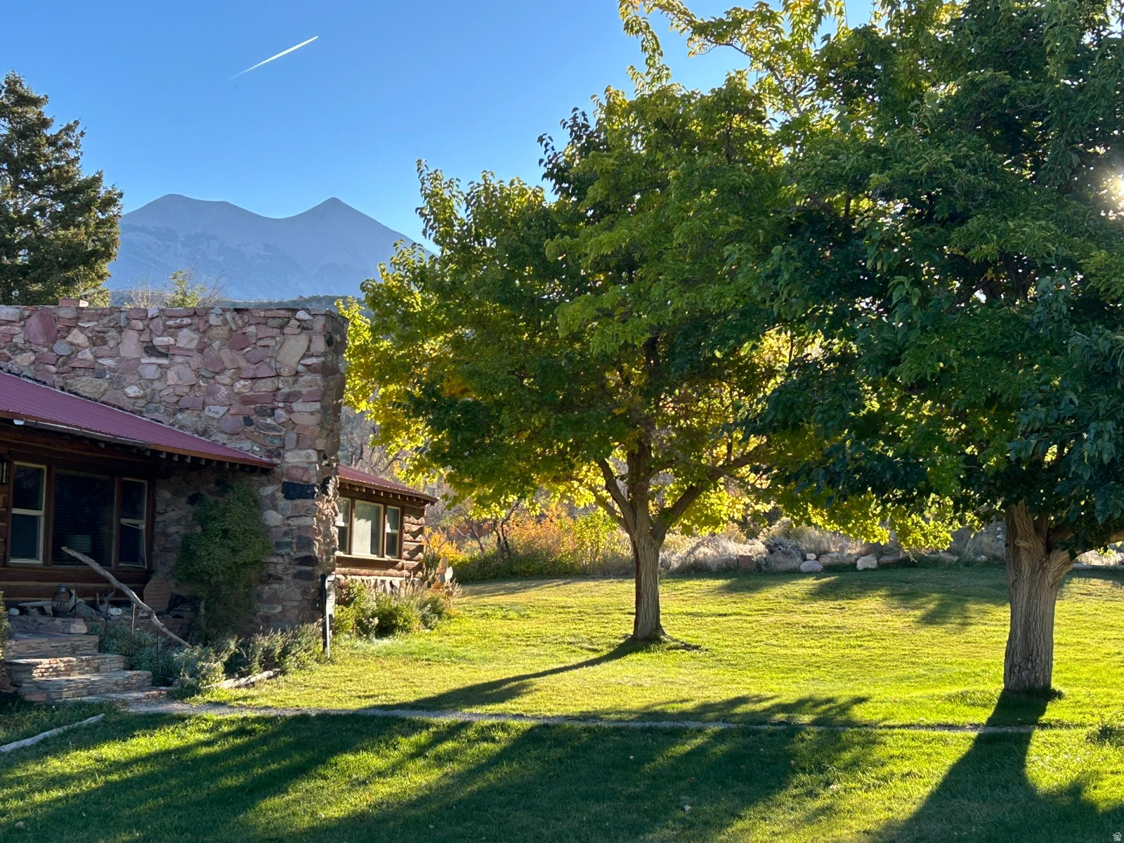 The Ranch House is nestled in the high desert oasis of Pack Creek Ranch, just 15 miles south of Moab. Built in the mid 1950s, this renovated heritage log cabin offers a rustic elegance providing all the conveniences of home while also being a quiet, wild refuge in the foothills of the La Sal Mountains. Pack Creek Ranch is an iconic and highly desirable location offering a rare and sought after Moab address with a coveted overnight rental license. At 2,277 square feet and fully furnished, the Ranch House presents a 'turn-key' revenue opportunity for nightly rentals. It is one of the most beautiful homes on this stunning 15-acre ranch with an abundance of mature trees and irrigated green space. Surrounded by a generous endowment of wild and cultivated land, the Ranch House enjoys both privacy and serenity. Walking into the Ranch House is like entering another world. One immediately feels at home with its cozy furnishings and walls adorned with aesthetic touches that connect to the wonder and beauty of the Colorado Plateau. This spacious cabin is a wonderful place for gatherings of friends and family. Big bedrooms, 2.5 bathrooms, a fully equipped kitchen, a large living room with floor to ceiling library and rock fireplace, all combine to make Ranch House an unforgettable setting for the people who live or visit here. Sliding doors off the dining room open out onto a deck overlooking the spa area hot tub, sauna and pool. Being the closest cabin to these amenities, Ranch House enjoys frequent first-access and often private use of the spa facilities. This is a year-round property that rejuvenates. Sitting at 6,000 feet, Ranch House offers respite from summer heat and the hustle and bustle of Moab. Everywhere you look, there are breathtaking, unrestricted views of Mt Tukuhnikivatz and the Moab Rim. Here is an extraordinary basecamp for outdoor enthusiasts looking for a lifetime of exploration in the fabled canyon country of southeast Utah. Ranch House, currently used as a second home and overnight rental property, is held in an LLC. Should a buyer wish, the LLC can be dissolved after purchase. The sellers are Canadian owners and as such are required to follow the FIRTPA regulations at the time of sale. Details will be provided to potential buyers. Please contact the seller's agent for more information.